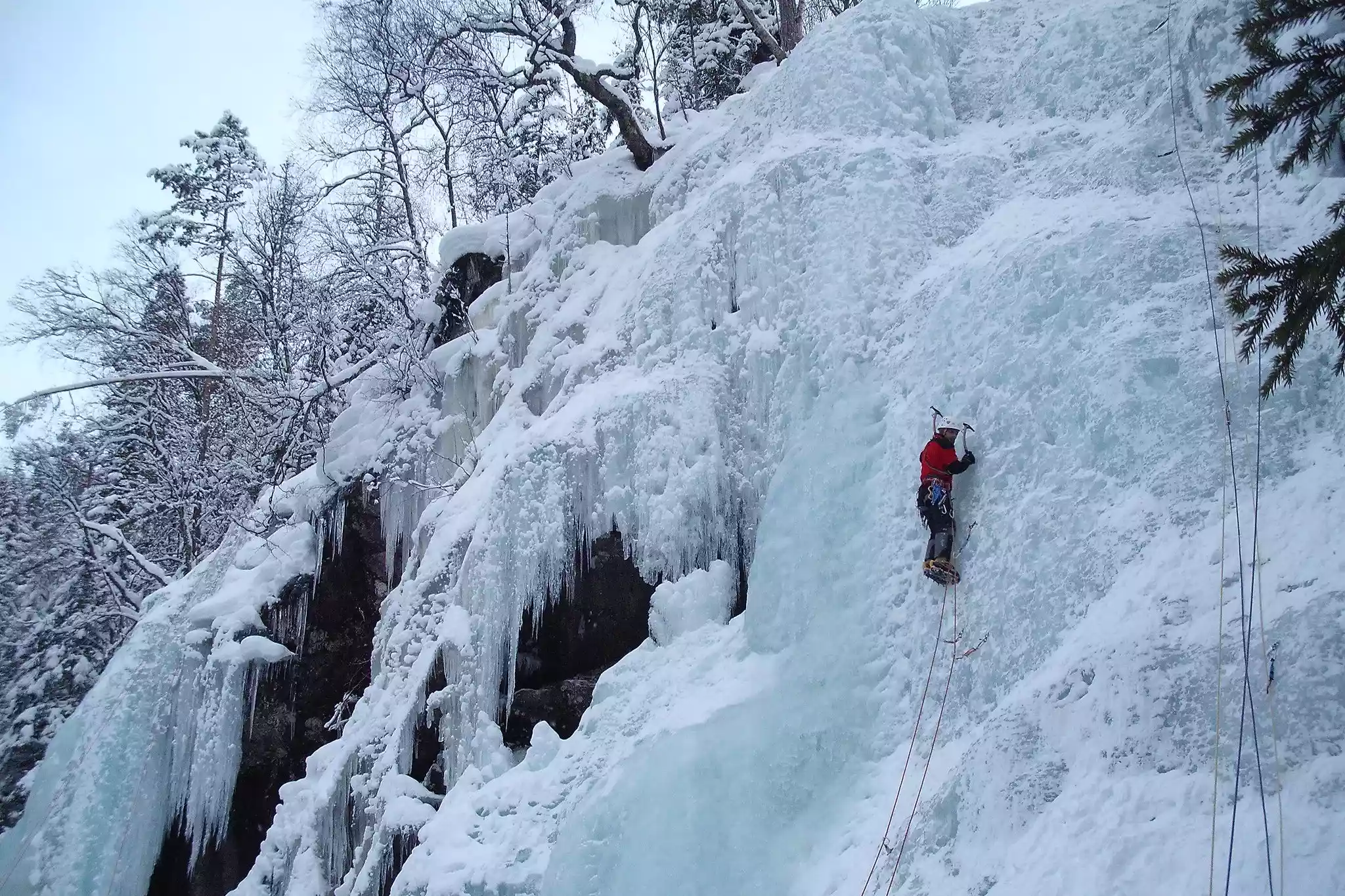 Climber ascends a frozen ravine in Rjukan, Norway