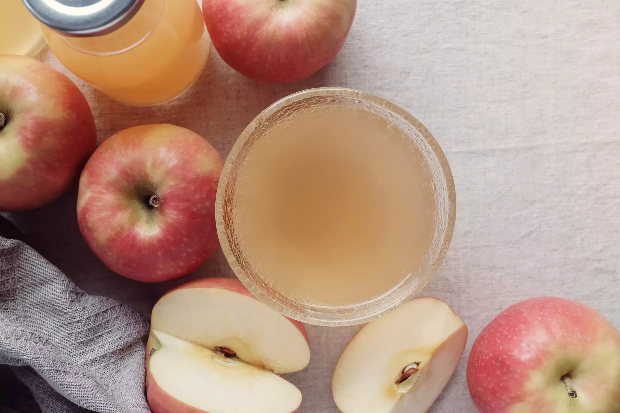 Top view of apple cider vinegar surrounded by apples