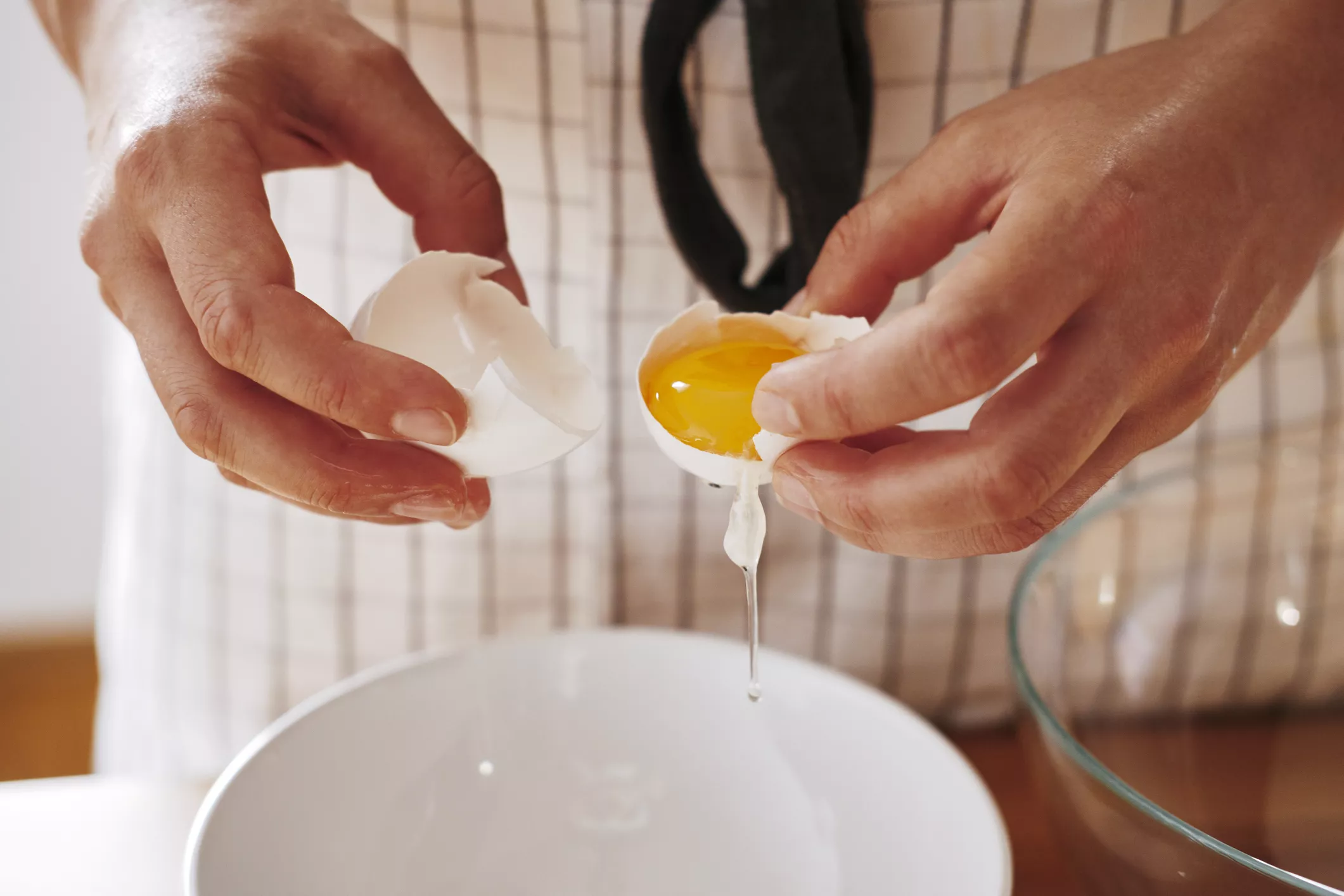 Woman's hands separating egg, close-up