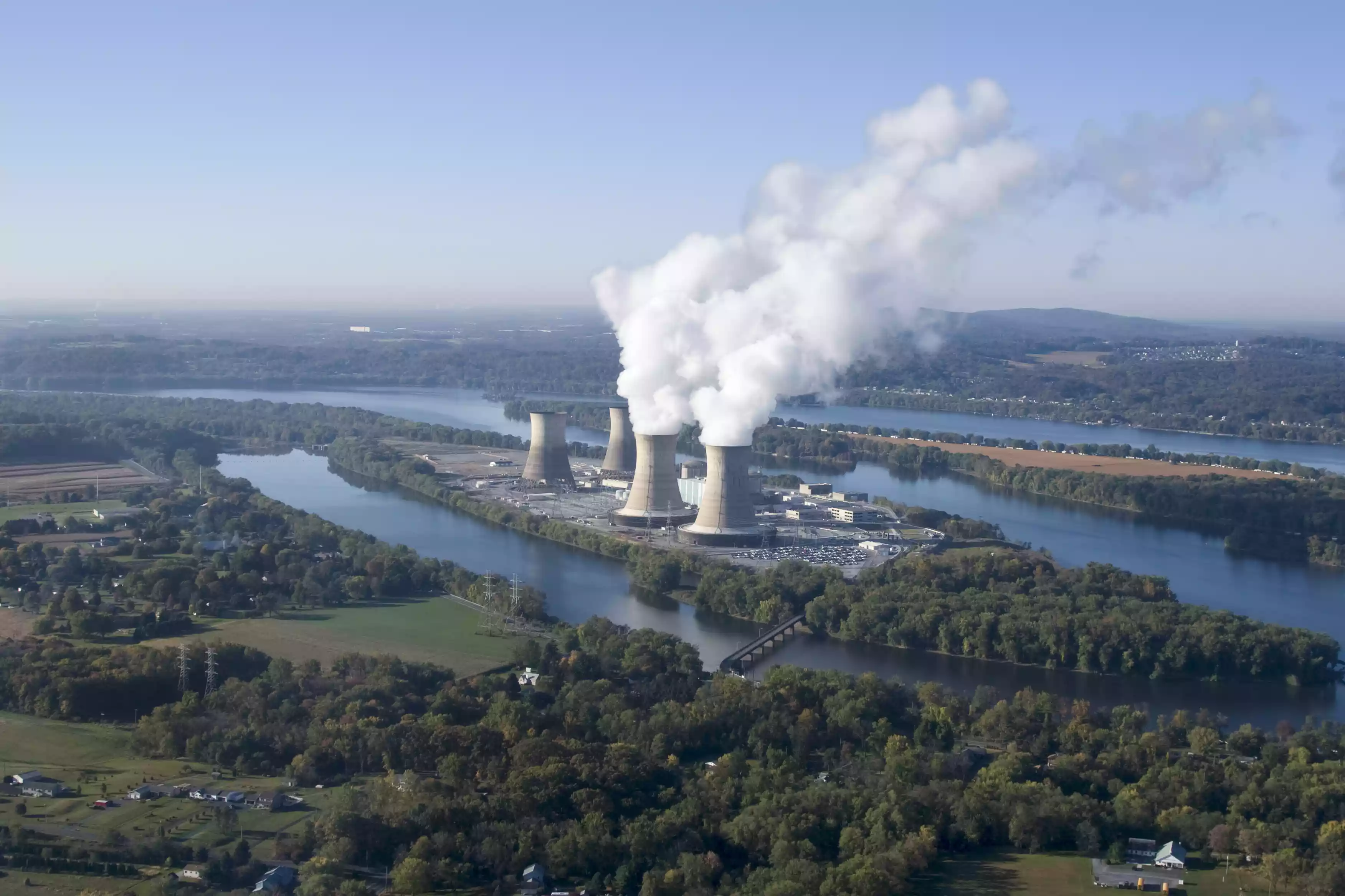 Aerial view of Three Mile Island nuclear power plant with smoke billowing out of stacks 