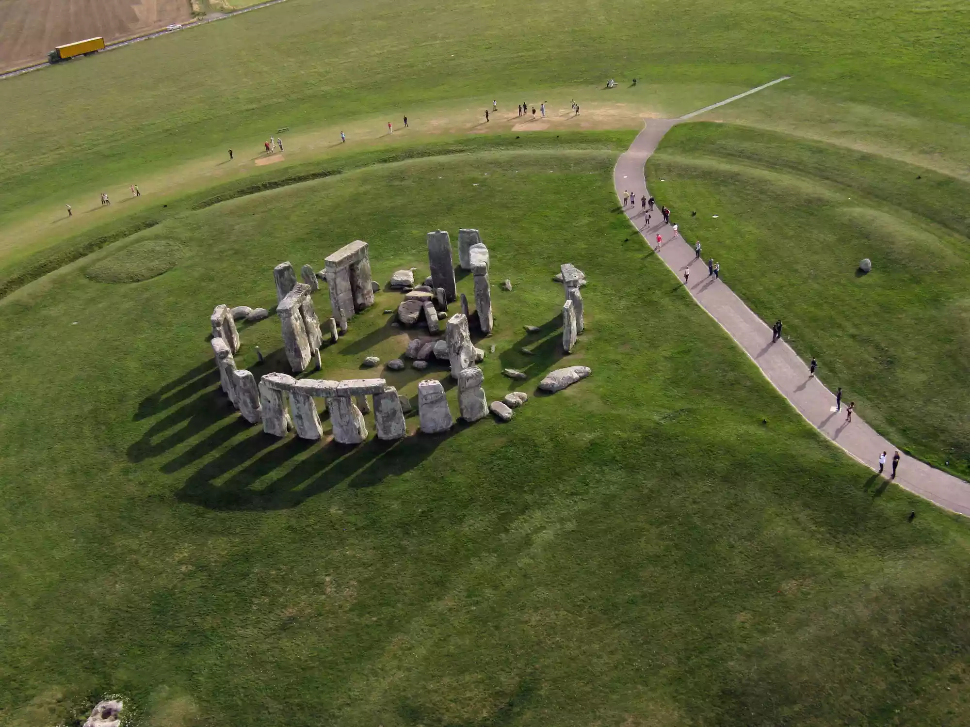 An overhead shot of Stonehenge and visitors on a nearby pathway