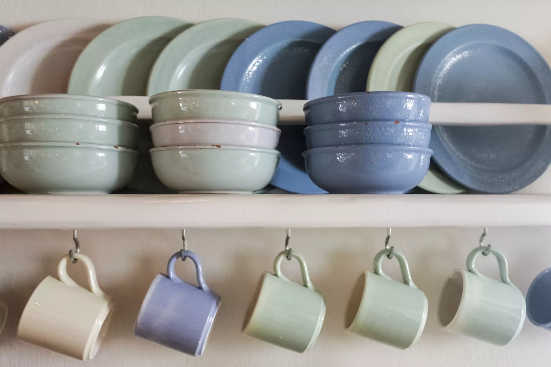 Ceramic plates, mugs, and bowls on a shelf