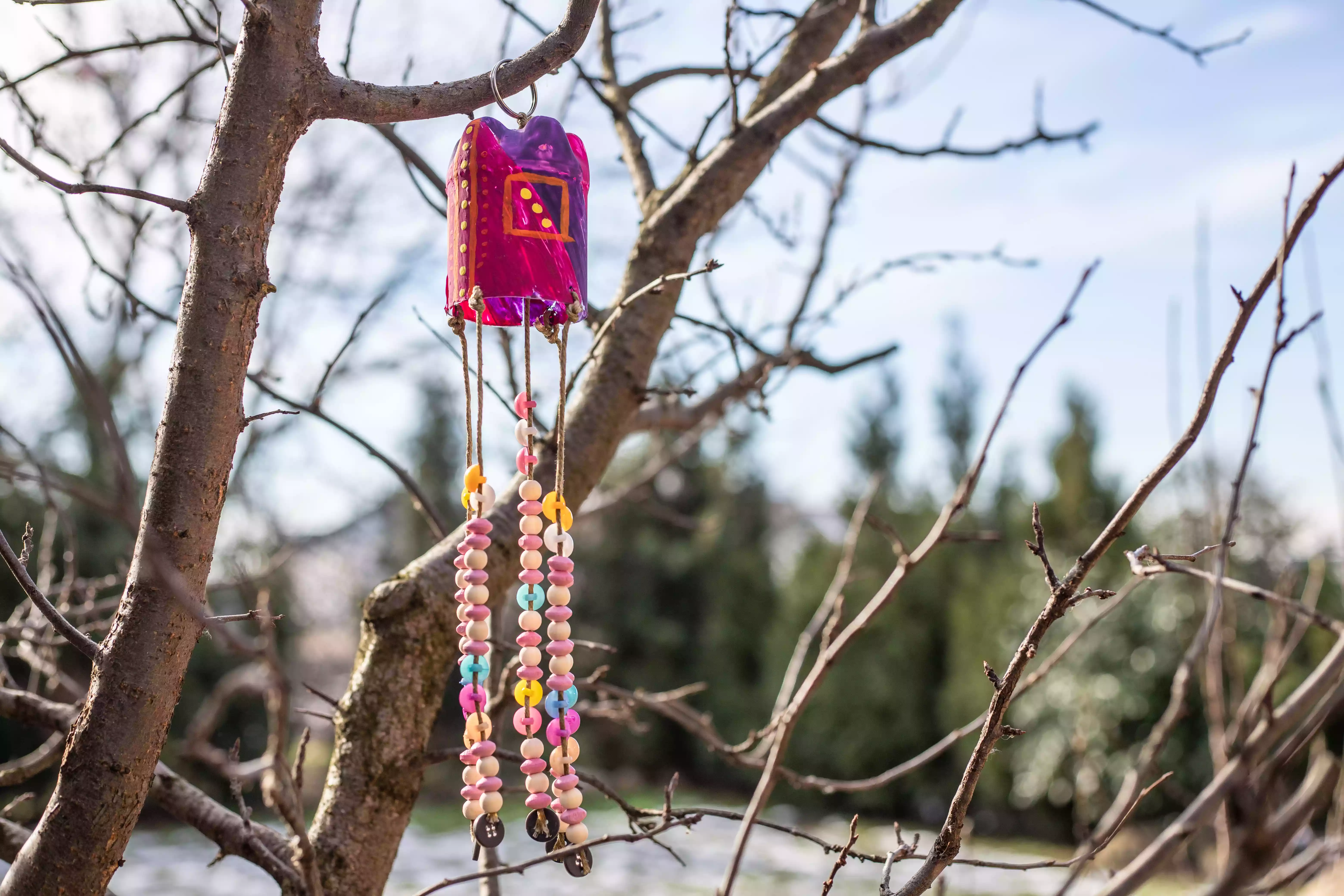 recycled plastic bottle as wind chime hung in tree