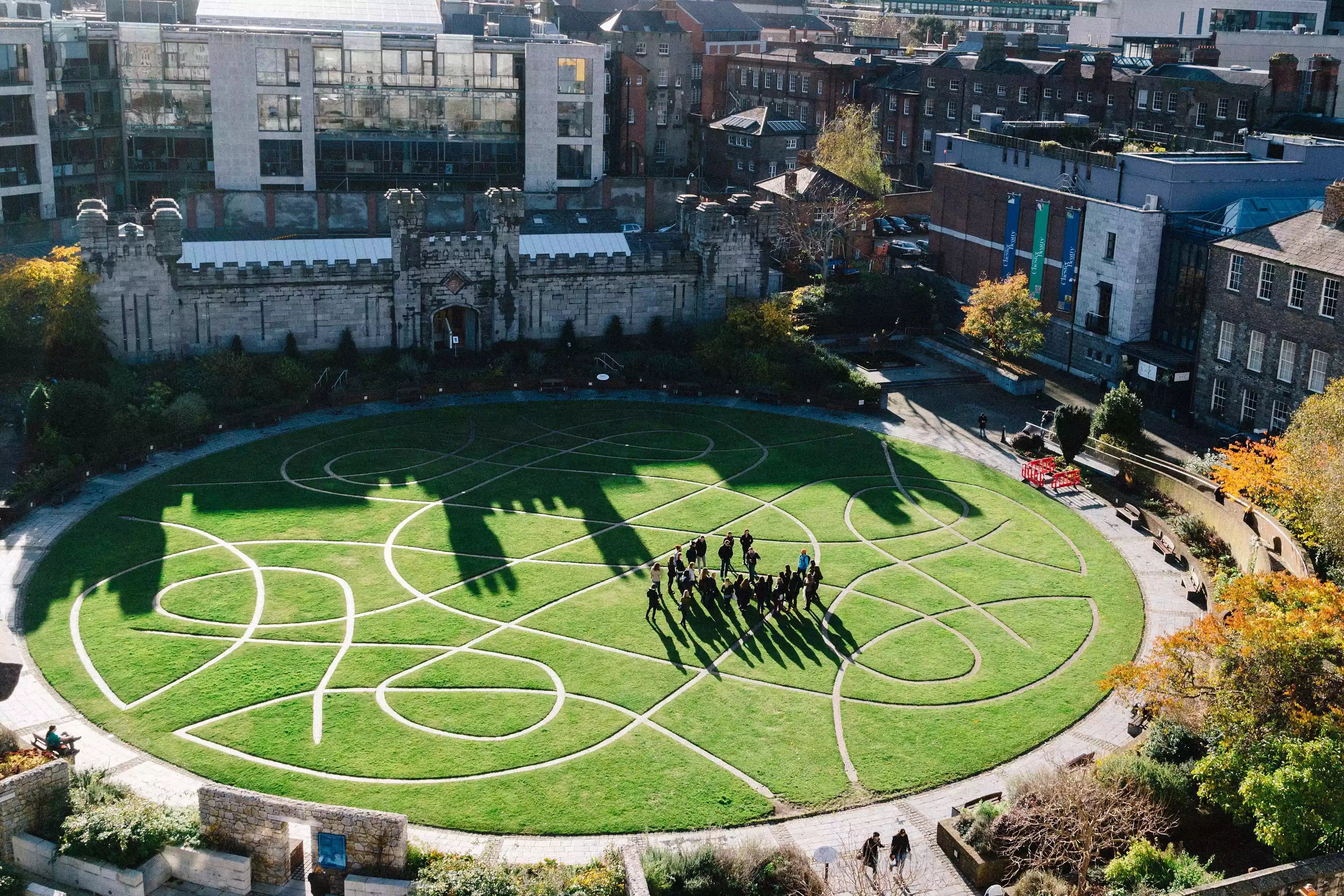 An overhead shot of a green lawn with a Celtic-inspired pattern of walkways