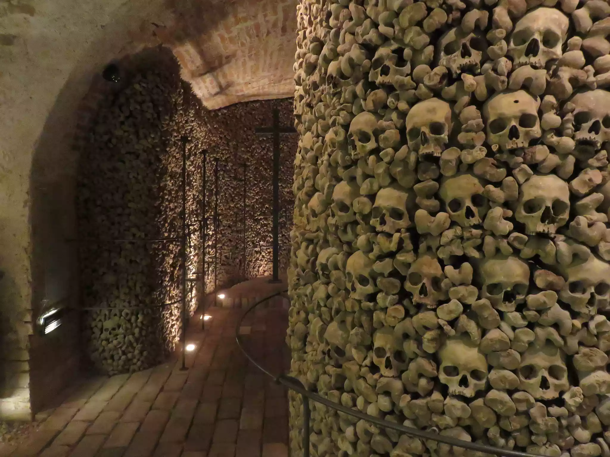 A wall made of human skulls and bones along a hallway in Brno Ossuary