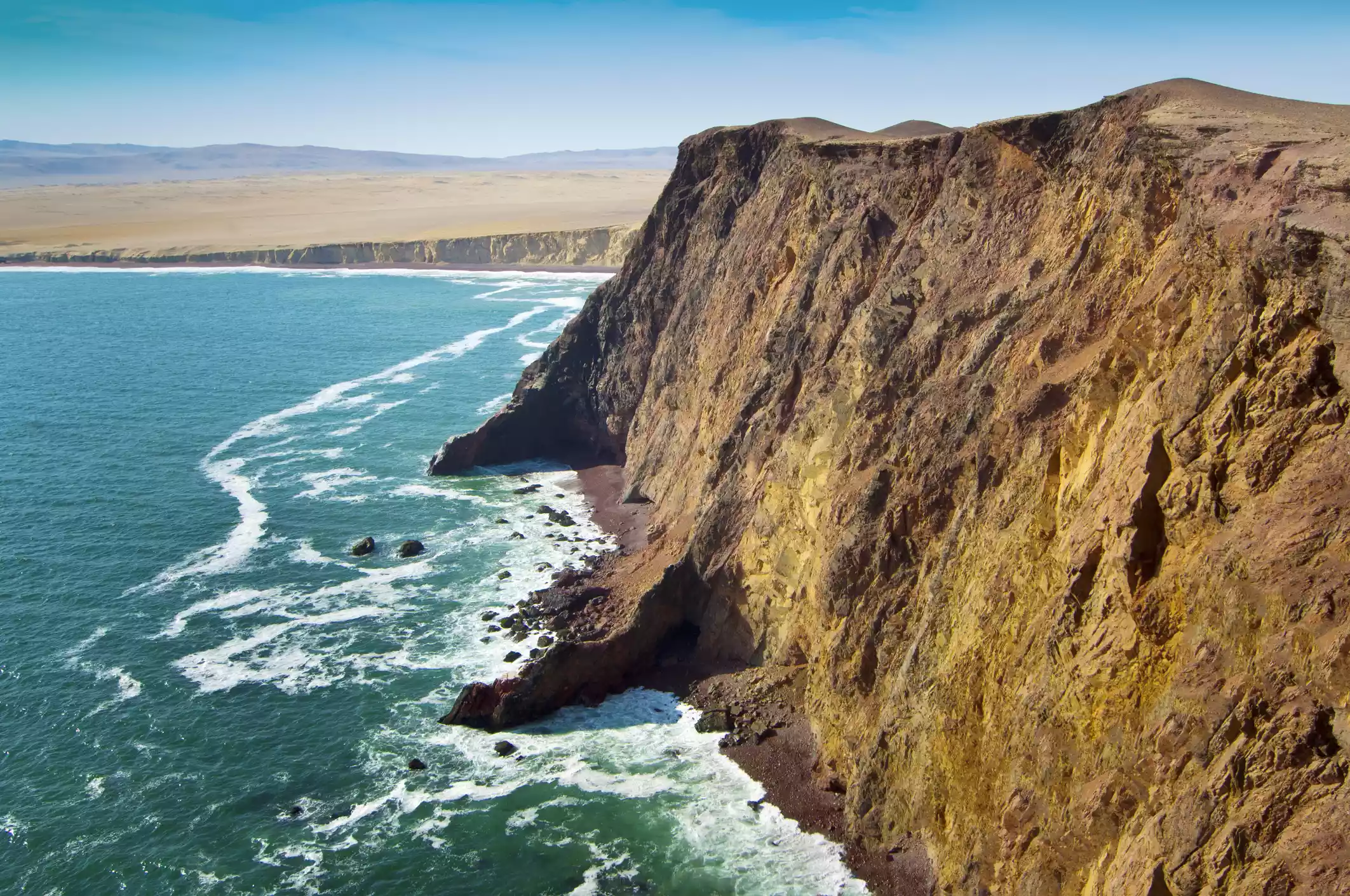 The Paracas cliffs rise above the water at Paracas National Reserve on a clear day