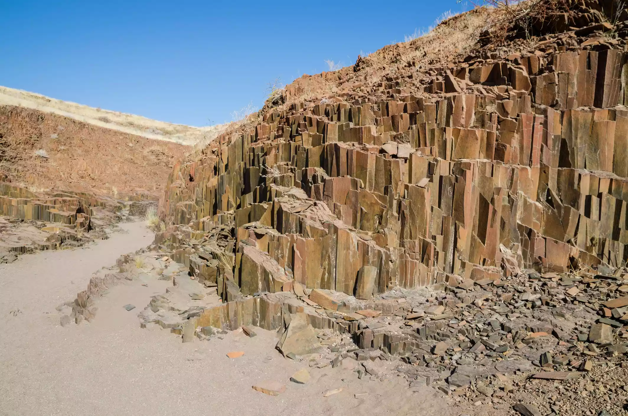 Red basalt columns resembling organ pipes against clear sky