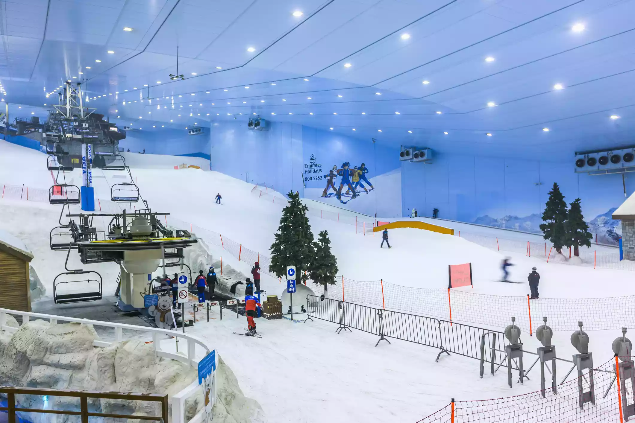 Ski Dubai at Mall of the Emirates indoor ski area with ski lift, trees, and white snow