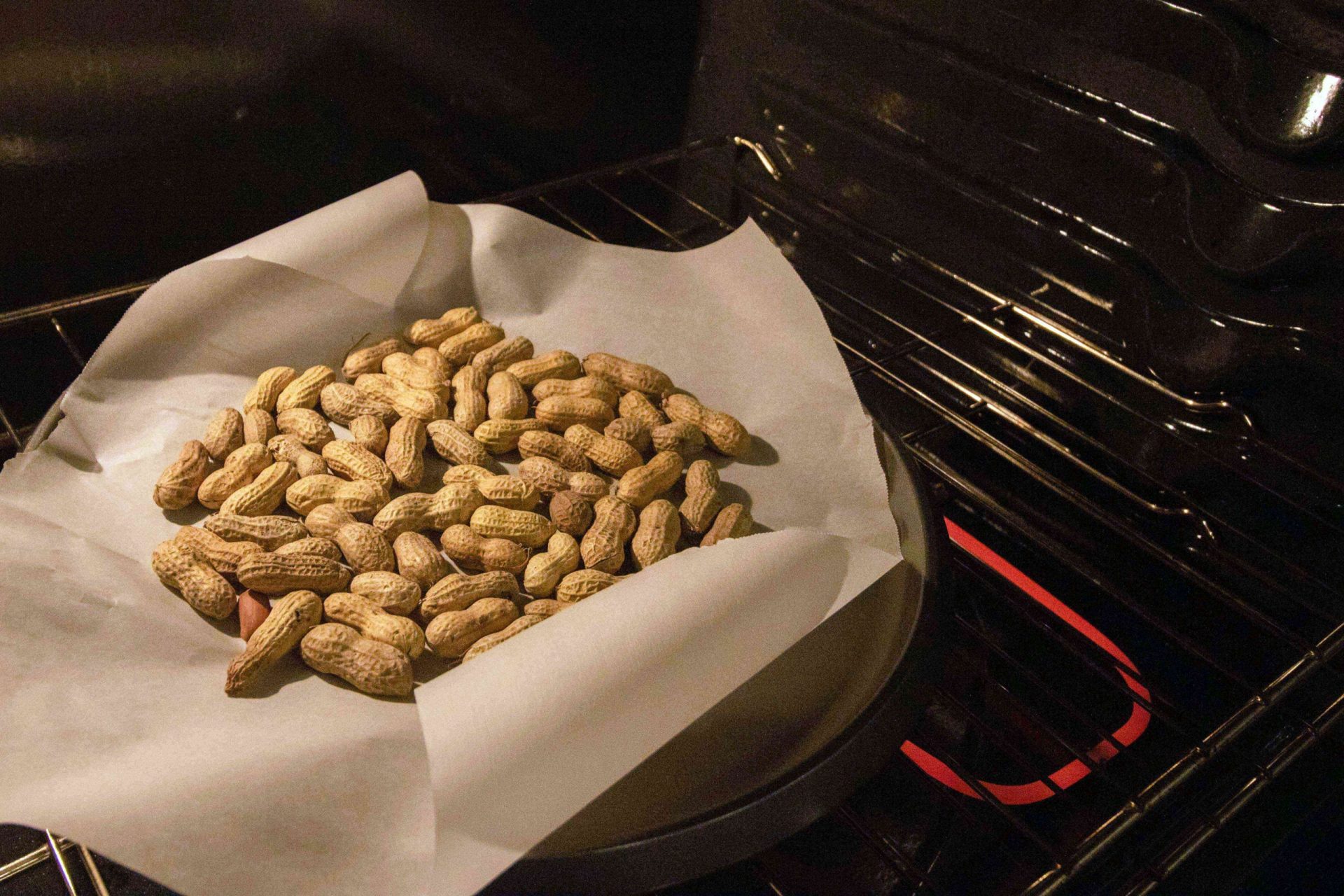 los cacahuetes recién cosechados se cuecen en la puerta del horno abierta