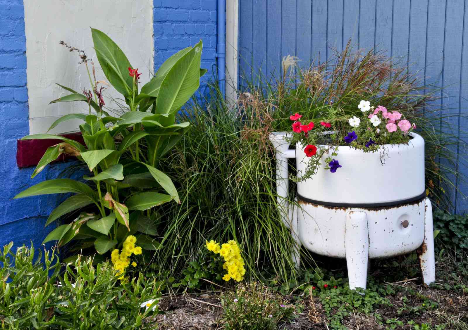 jardinera de exterior con flores, hecha con una lavadora rota