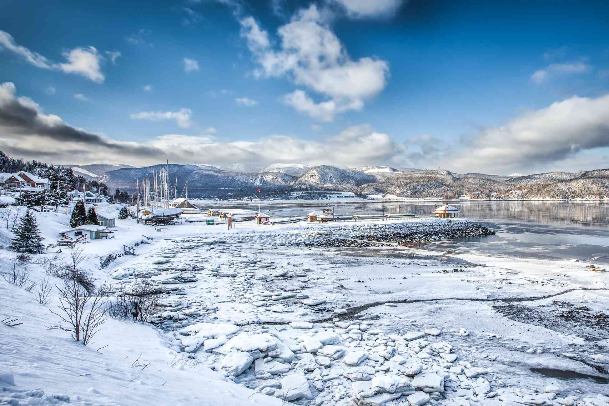Pueblo nevado y lago helado en las afueras de Saguenay