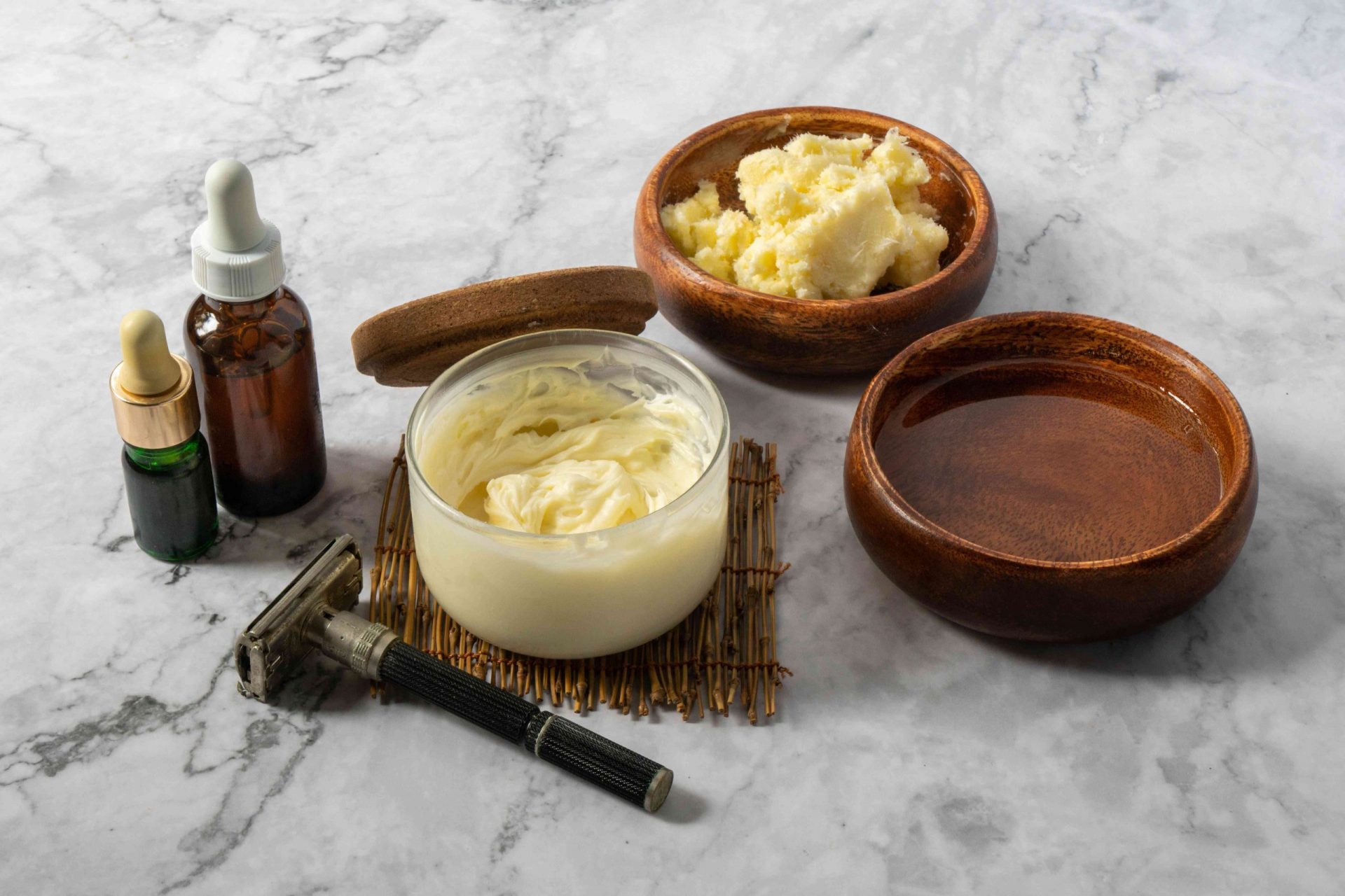 varios ingredientes para la crema de afeitar diy con aceites y manteca de karité cruda en cuencos de madera