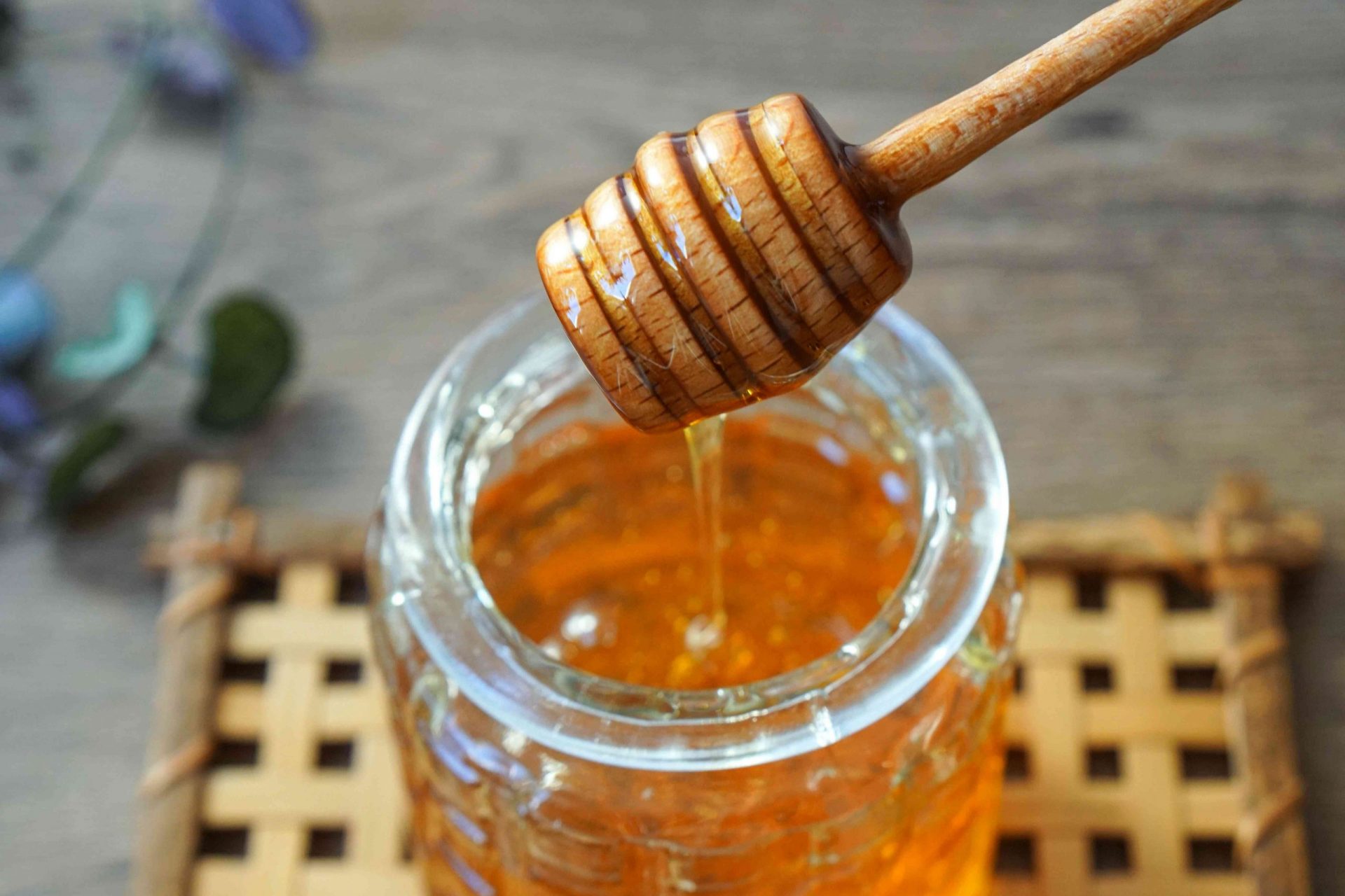 cazo de miel de madera se saca del recipiente de cristal que gotea miel