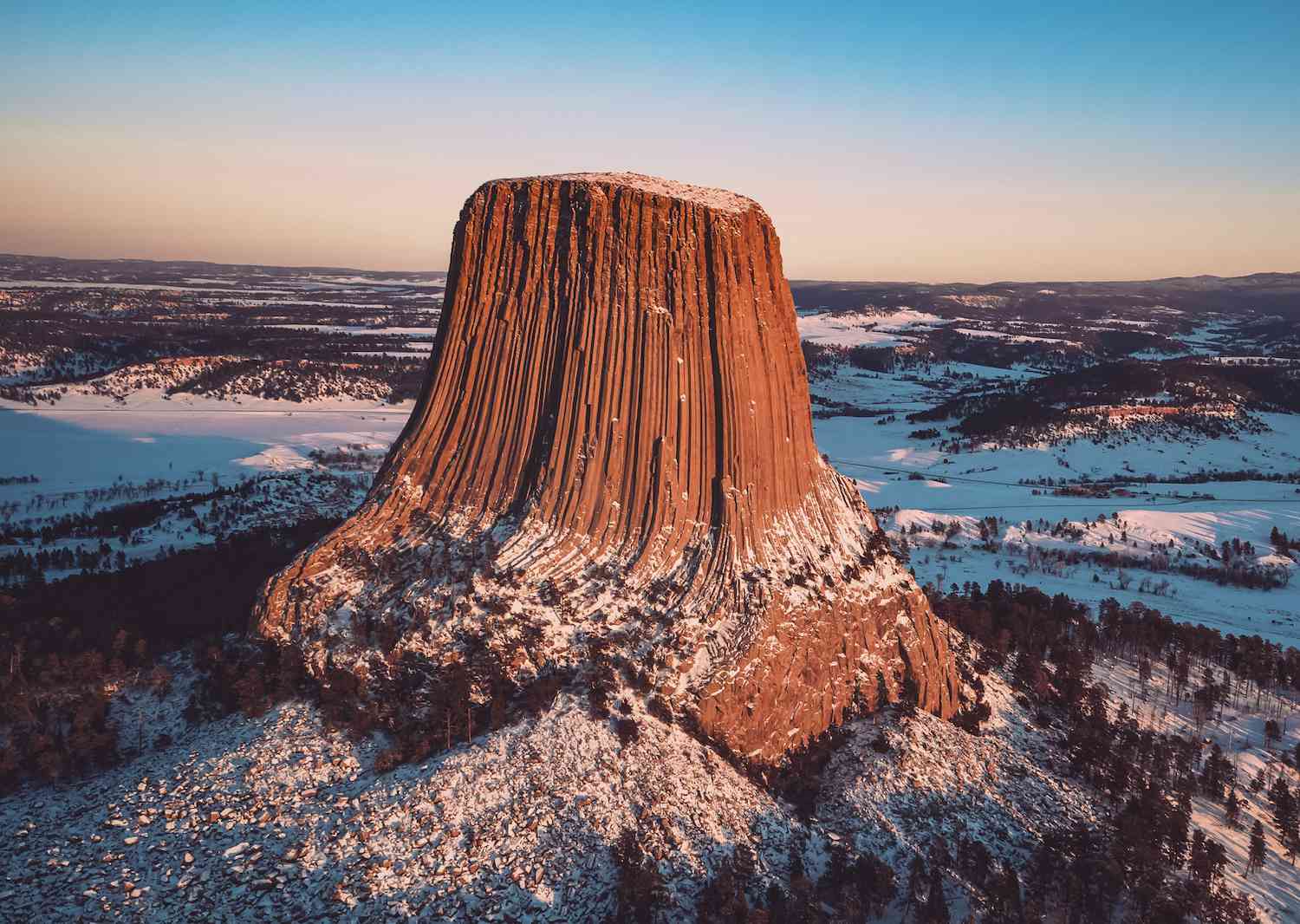 La Torre del Diablo se eleva sobre las Colinas Negras cubiertas de nieve al amanecer