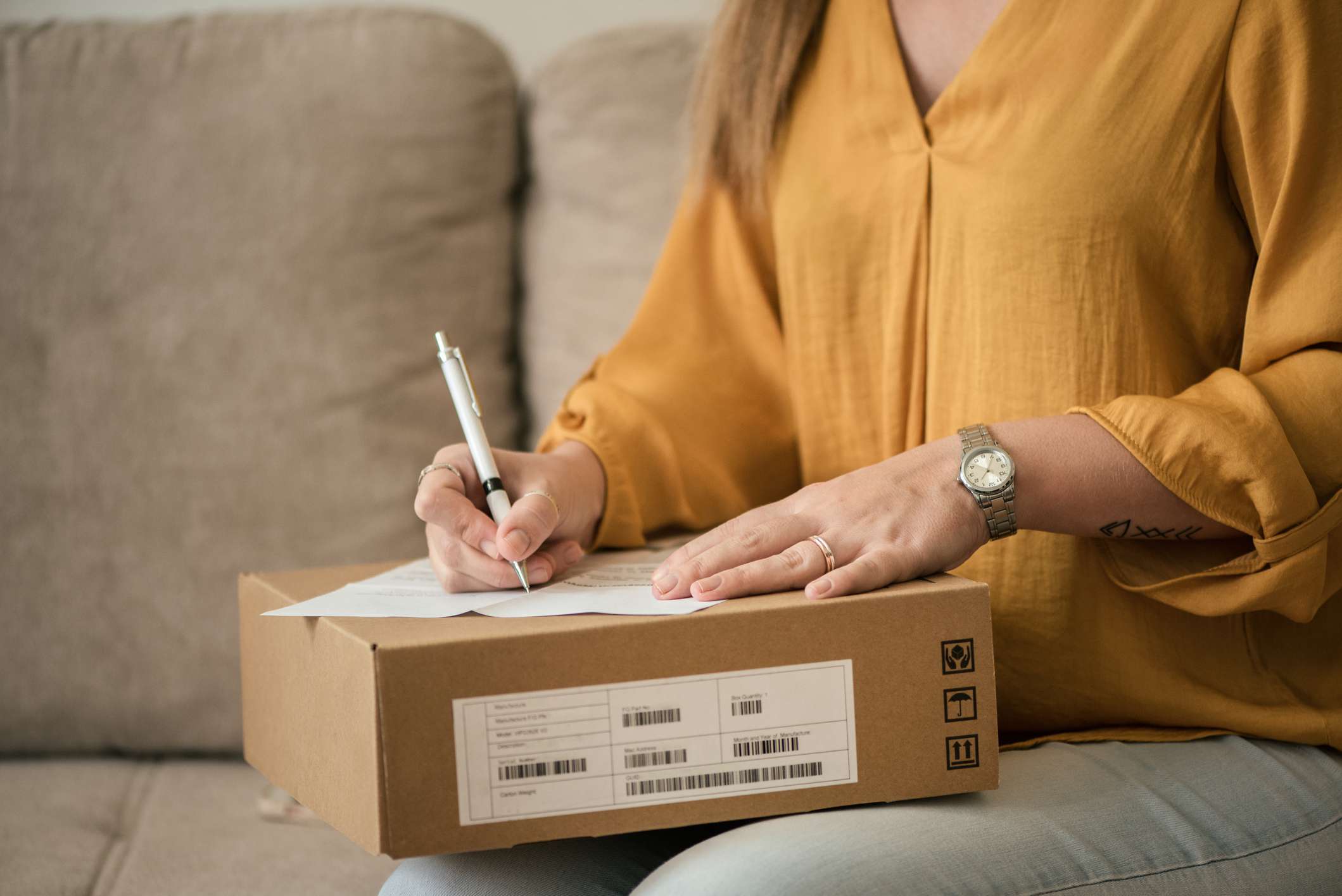 Una mujer escribiendo una devolución de un paquete