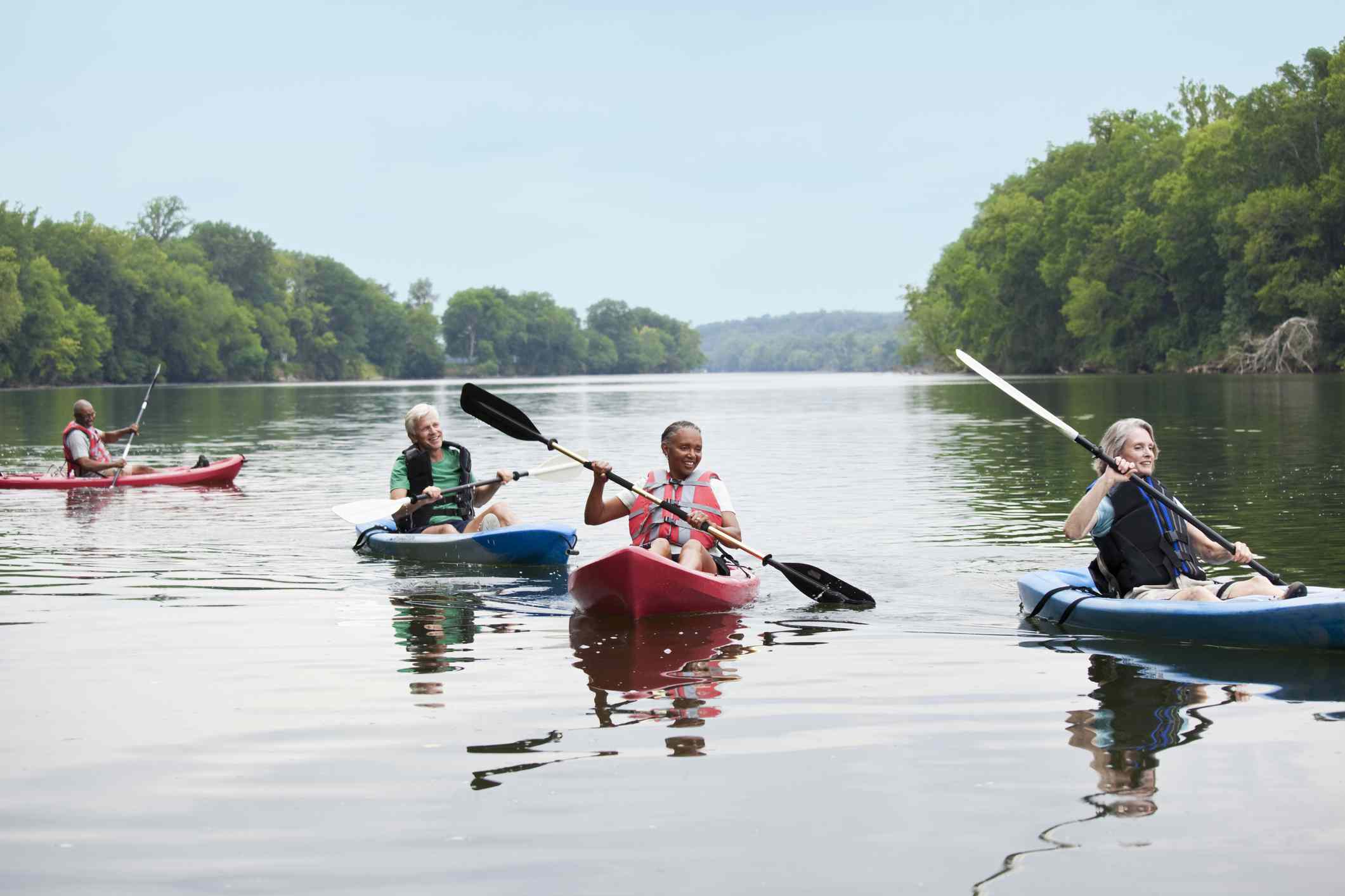 Personas maduras de edad avanzada haciendo kayak en un lago