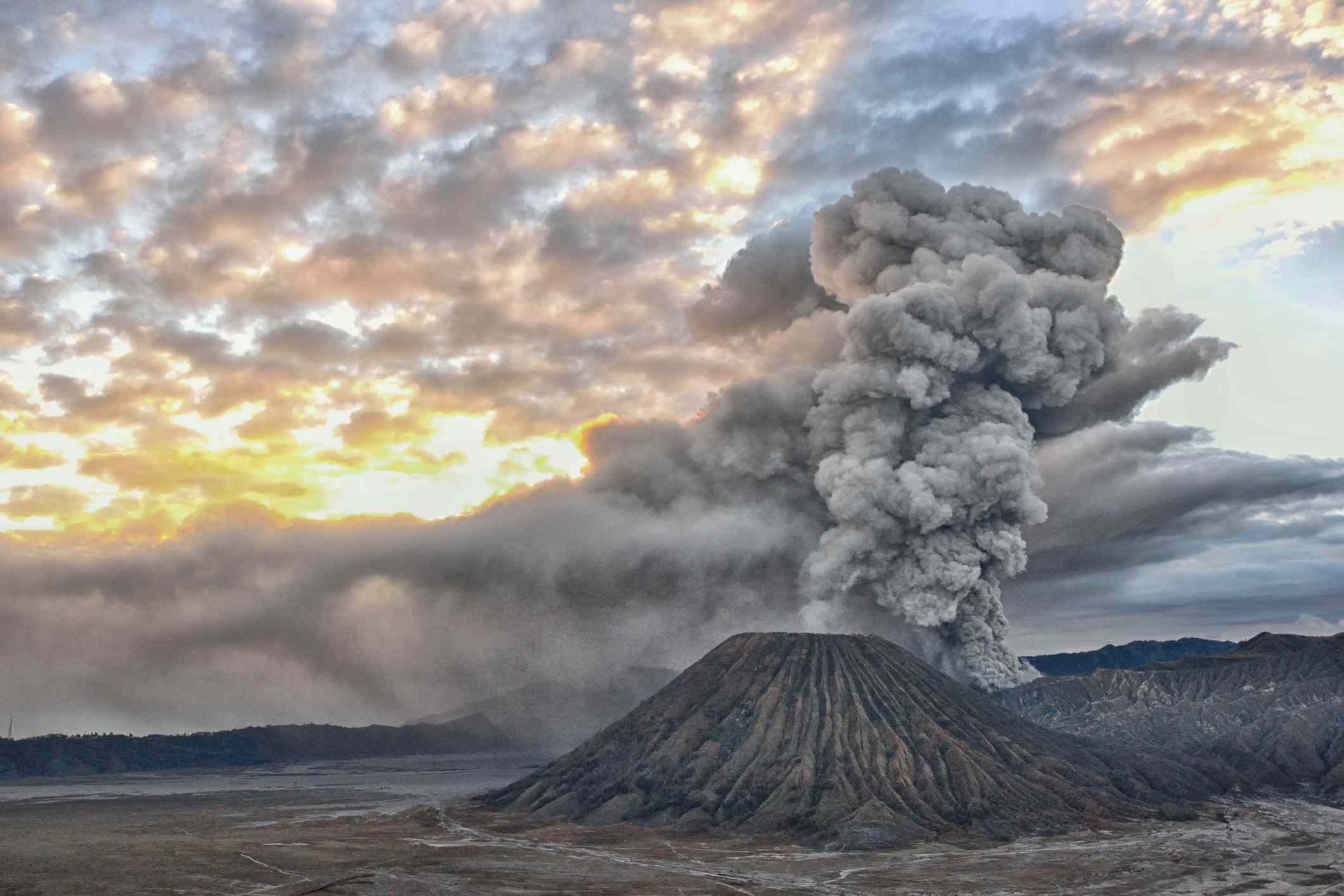 Una nube de ceniza se eleva desde un volcán al amanecer