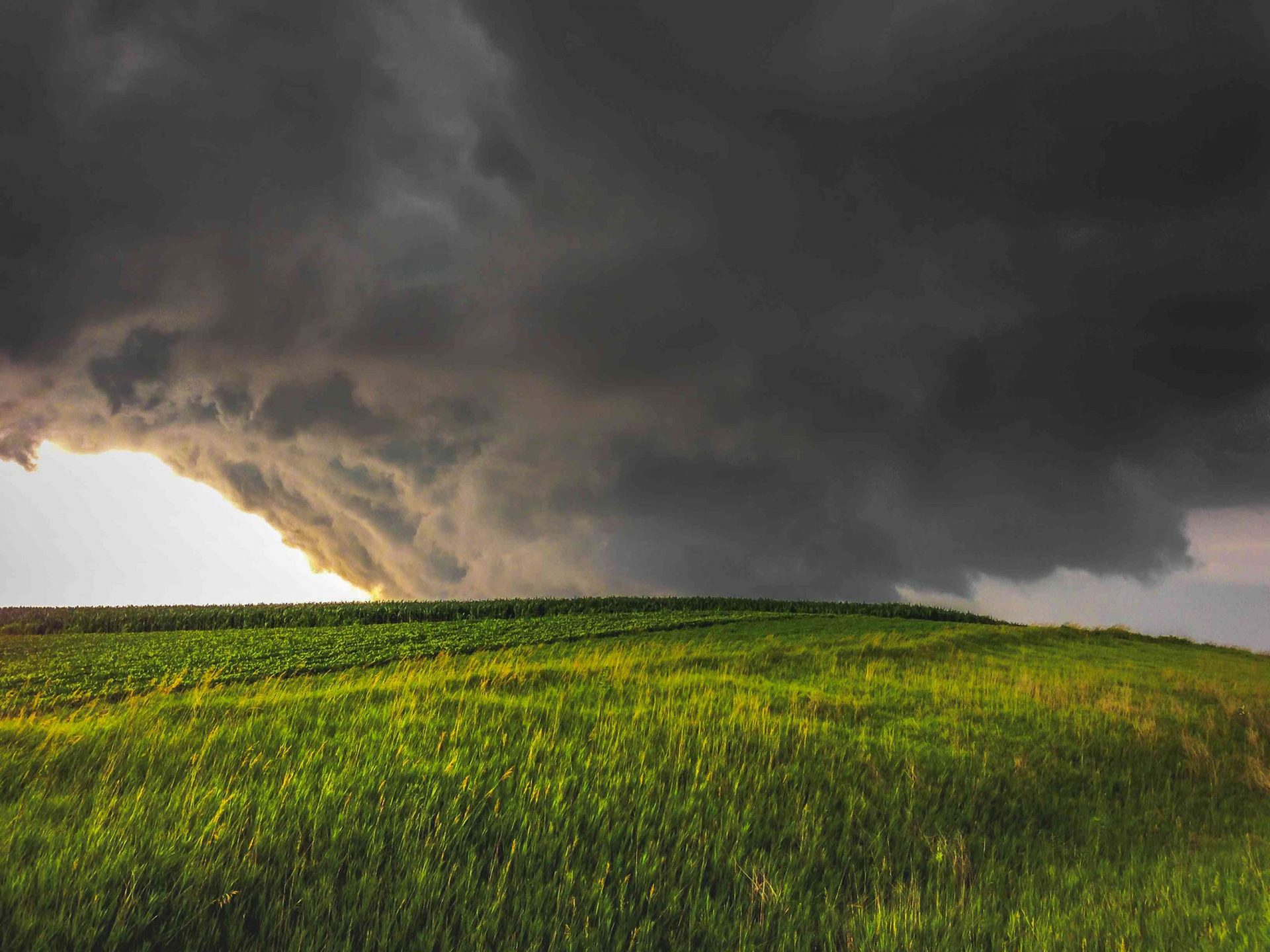 Un amplio tornado en cuña toca tierra al atardecer