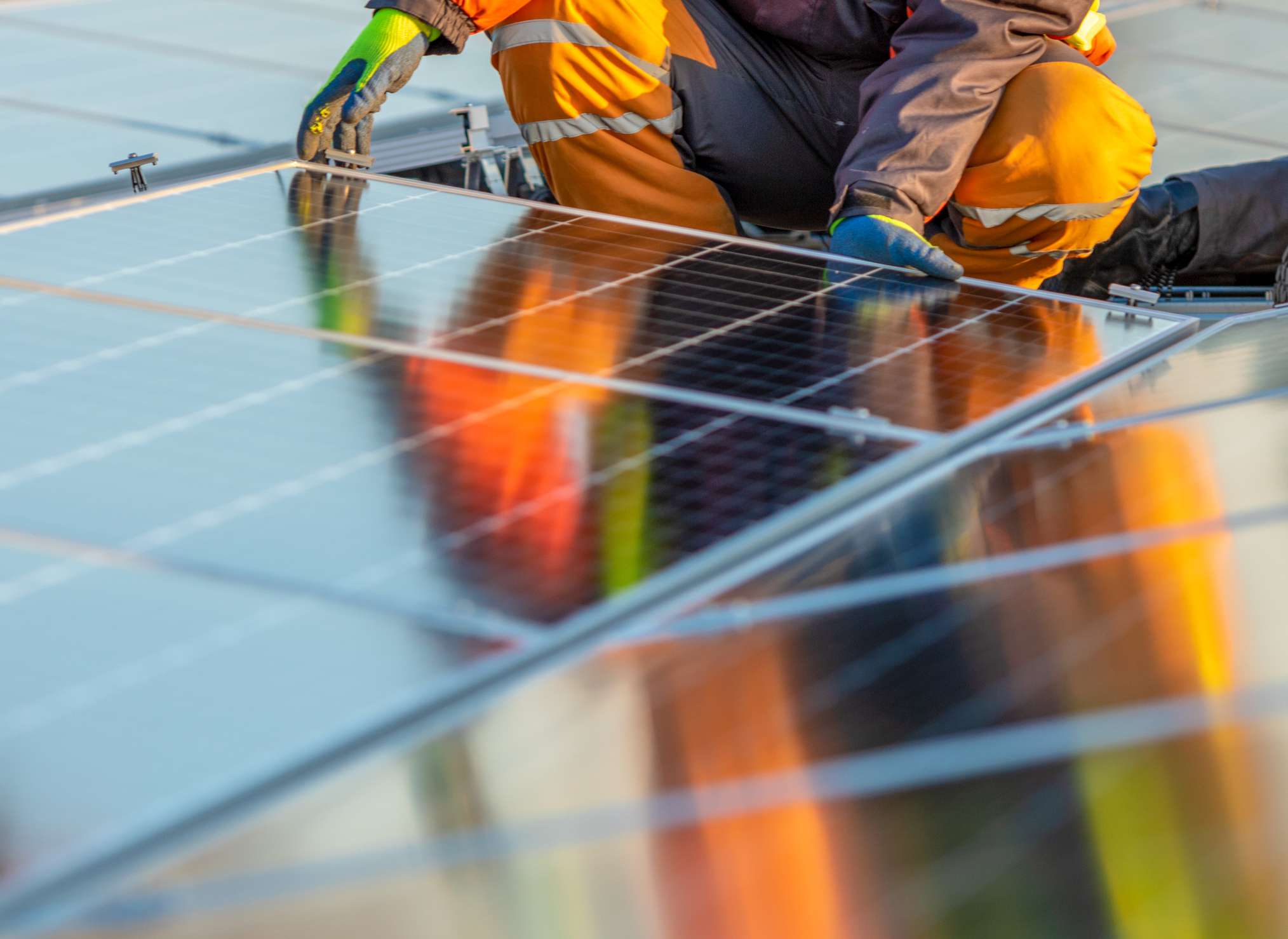 Una persona instalando paneles solares en un tejado
