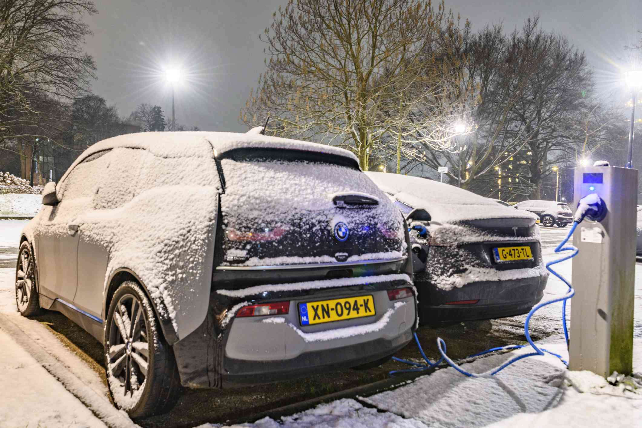 Vehículos eléctricos cargándose en la nieve en Zwolle, Holanda