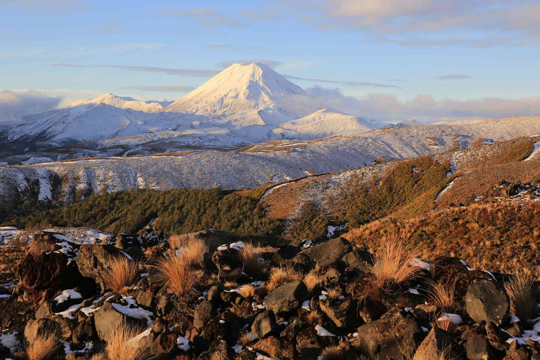 Volcanes activos del monte Ngaruhoe y del monte Tongariro cubiertos de nieve desde la base del monte Ruapehu, cubierto de rocas, Parque Nacional de Tongariro, Nueva Zelanda