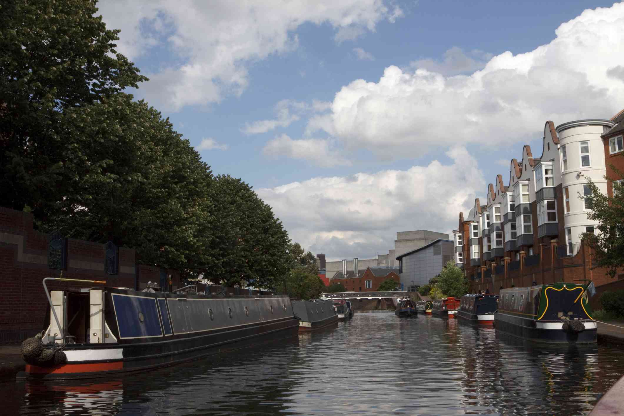 canal en Birmingham,Inglaterra con edificios a un lado y árboles al otro