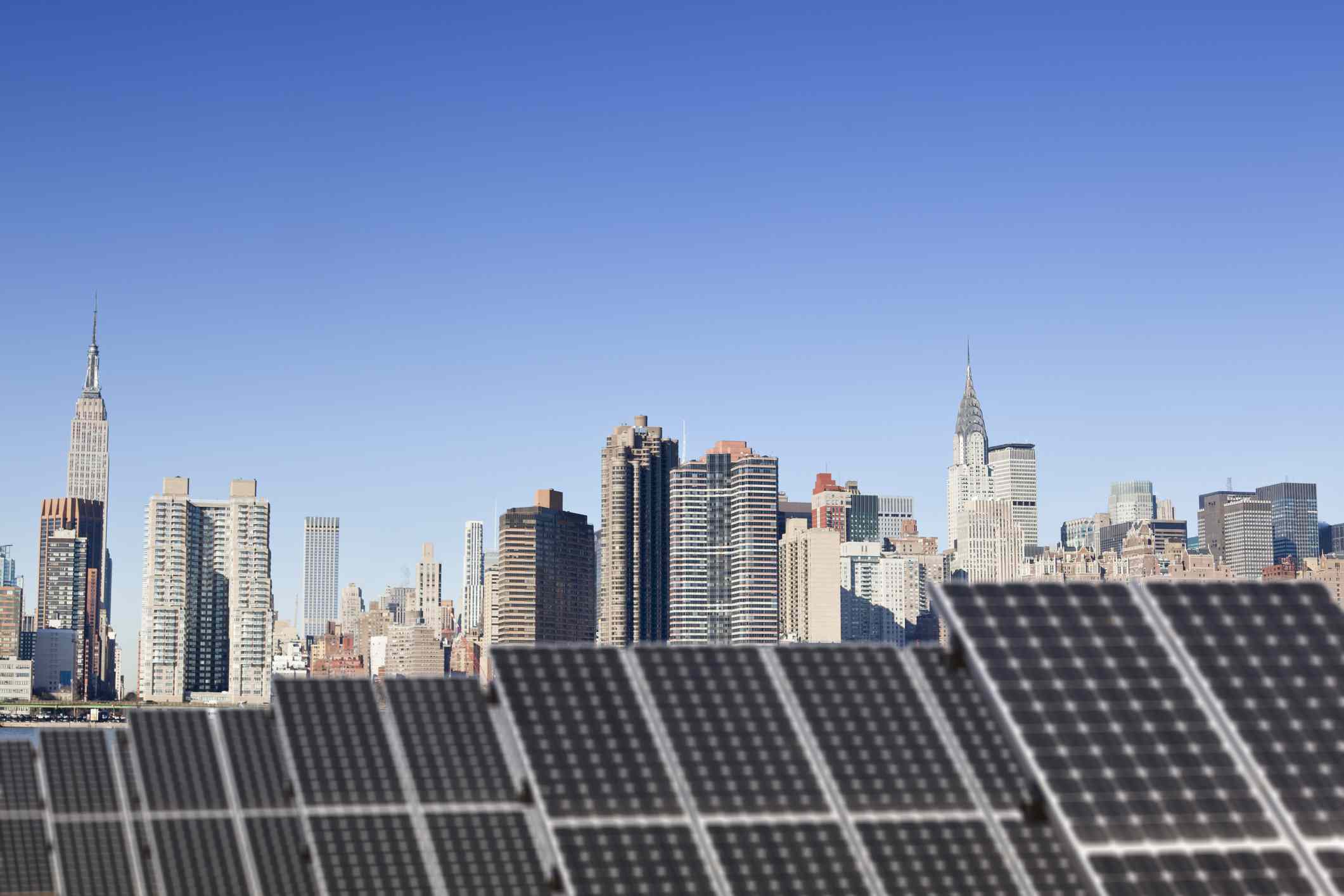 Paneles solares en un tejado con la ciudad de Nueva York de fondo