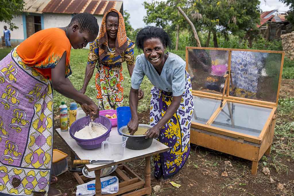 Las mujeres de Kenia cocinan pasteles con un horno solar