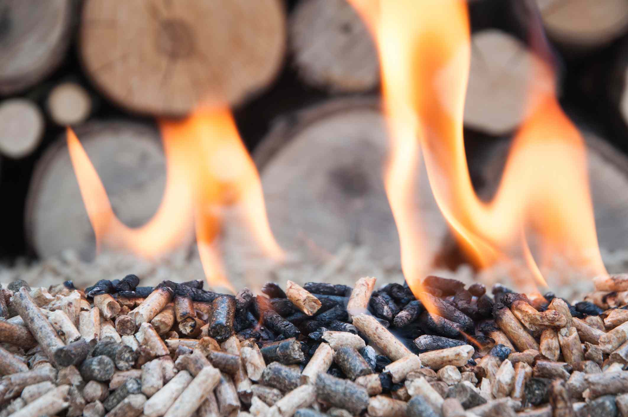 Pellets ardiendo con llamas con madera de fondo