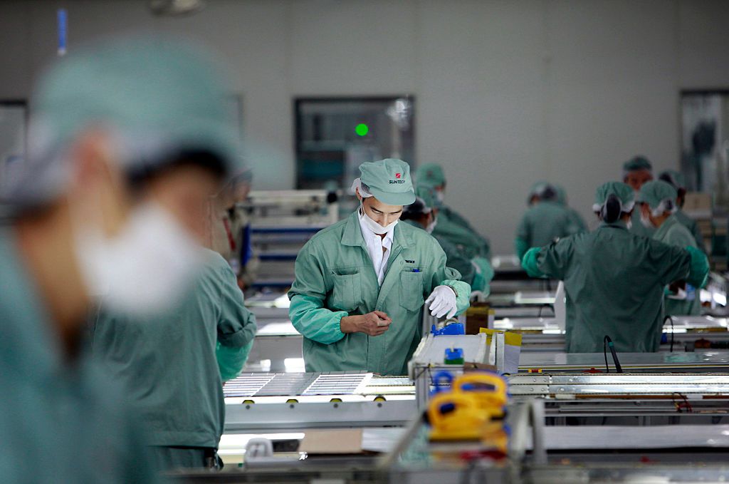 Los empleados montan paneles fotovoltaicos en la fábrica de Suntech Power Holdings Co. en Wuxi, provincia de Jiangsu (China)
