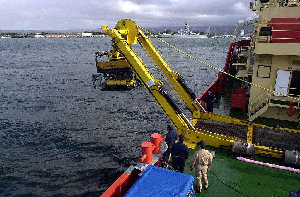 Un robot siendo bajado al océano por un barco
