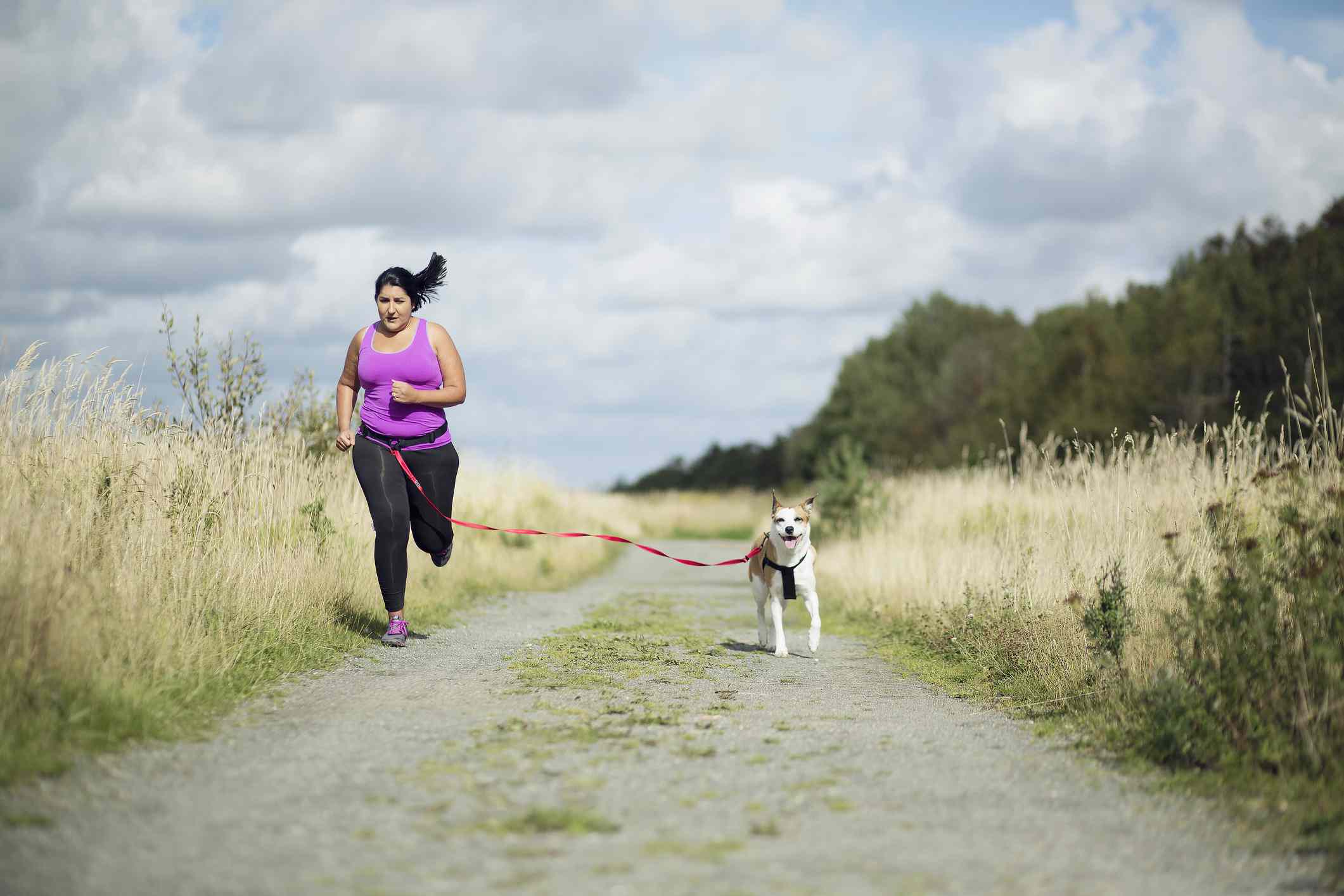 Mujer corriendo con su perro con correa