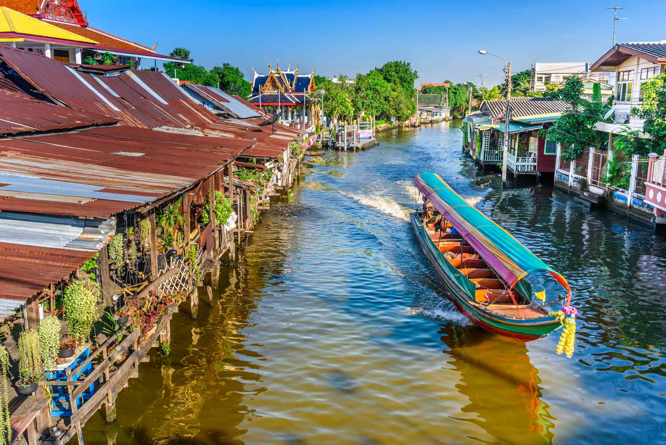 barco azul y naranja recorriendo un canal en Bankok, Tailandia