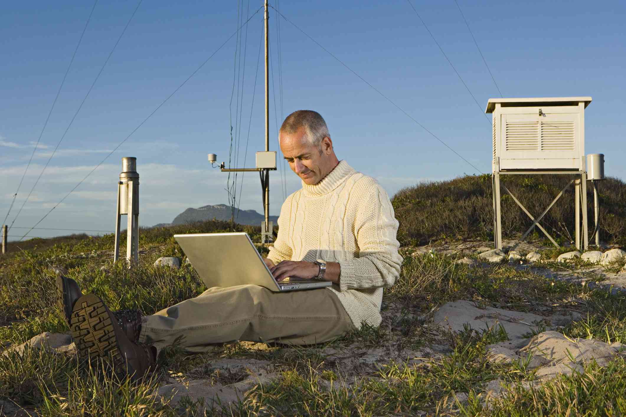 Un meteorólogo recoge datos de una estación meteorológica en la cima de una montaña