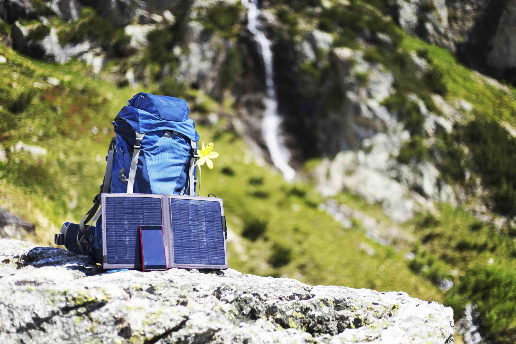 Una mochila con paneles solares portátiles al borde de un acantilado