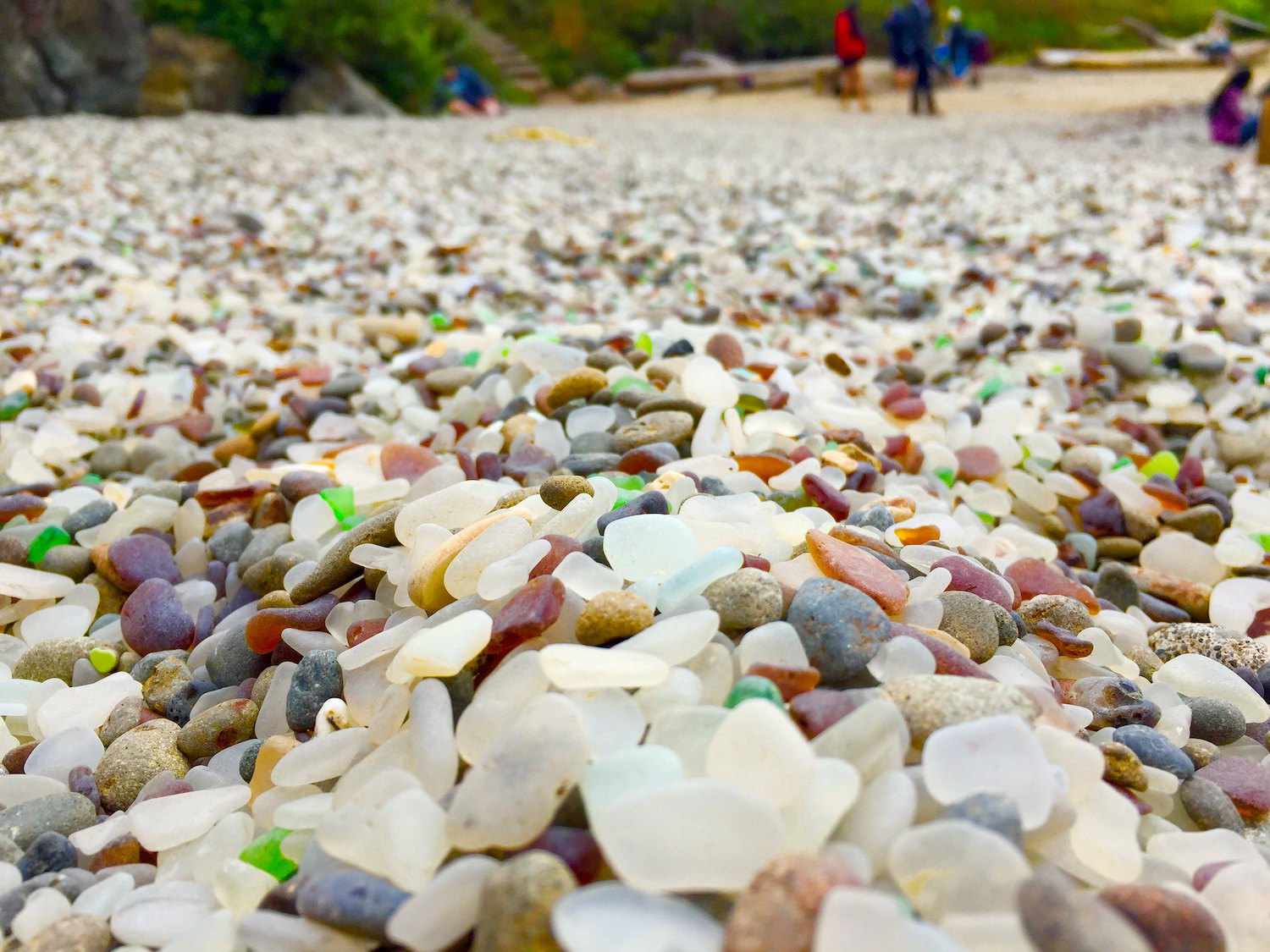 Un primer plano de pequeñas rocas lisas y cristal en la Playa de Cristal en California