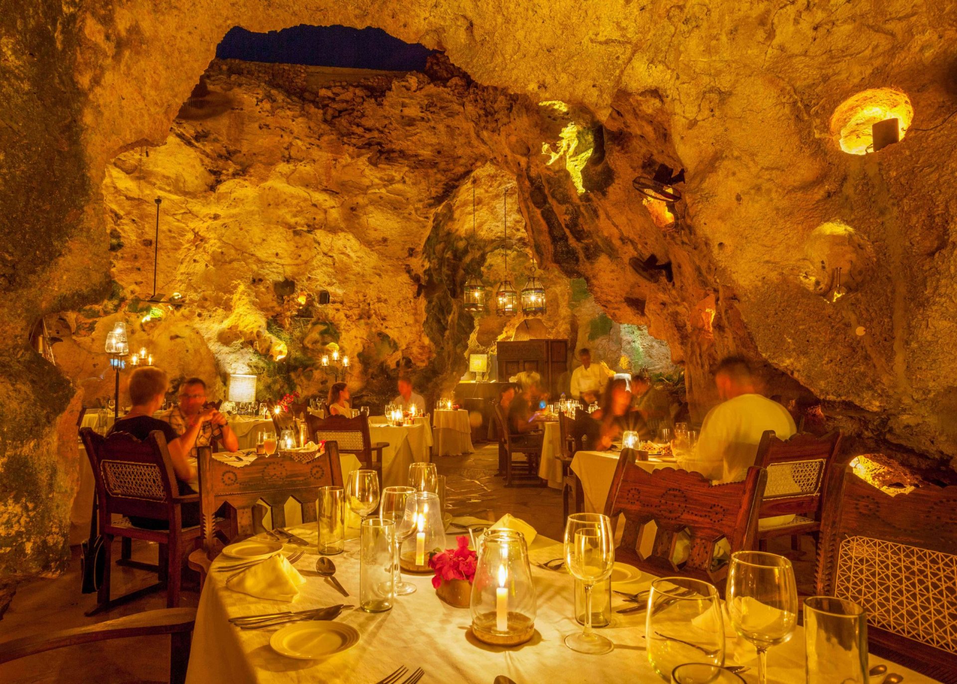 Restaurante Cueva de Ali Barbour en Kenia con luz de velas y comensales