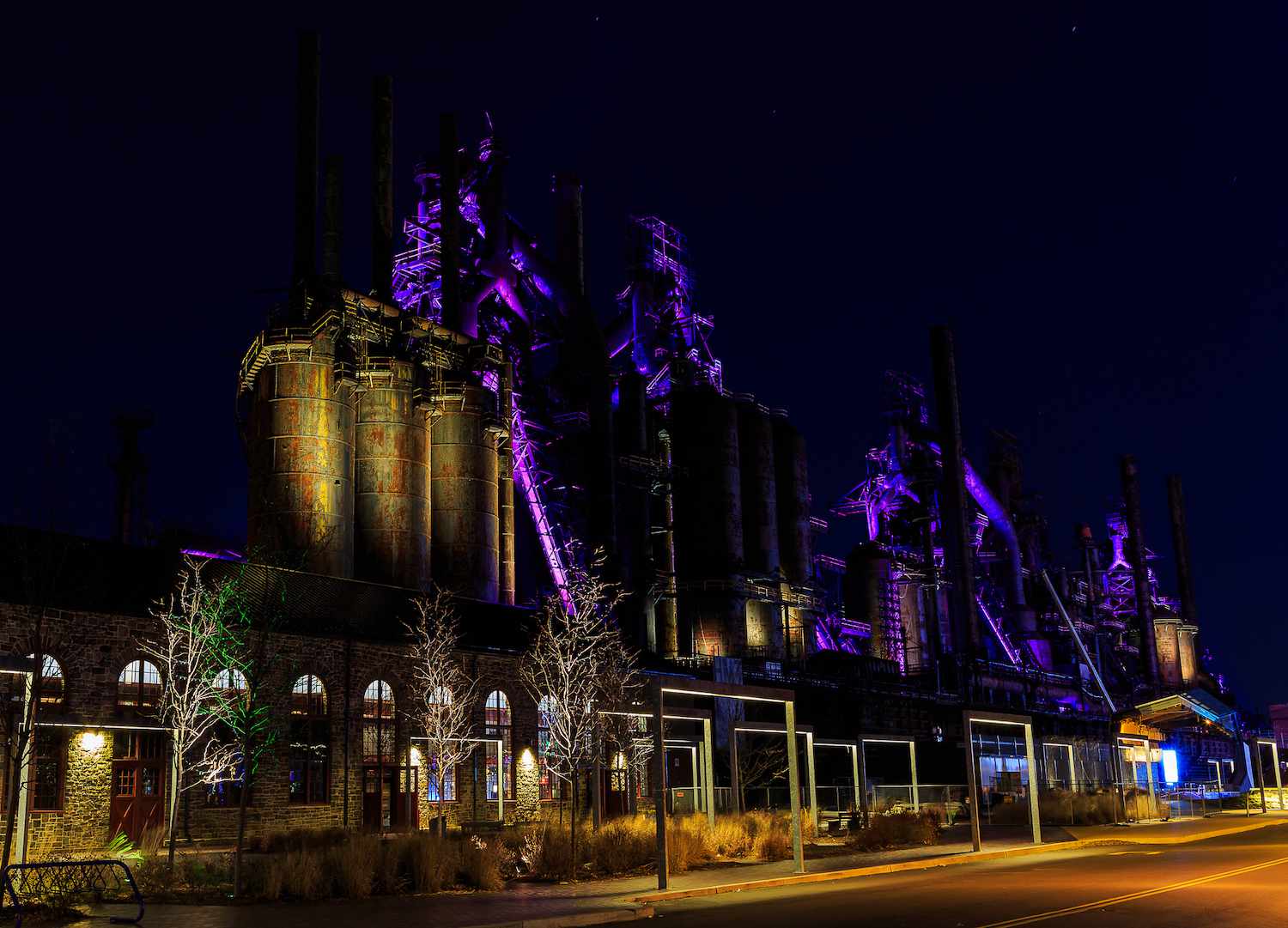 La entrada renovada de SteelStacks por la noche con los hornos iluminados en color púrpura