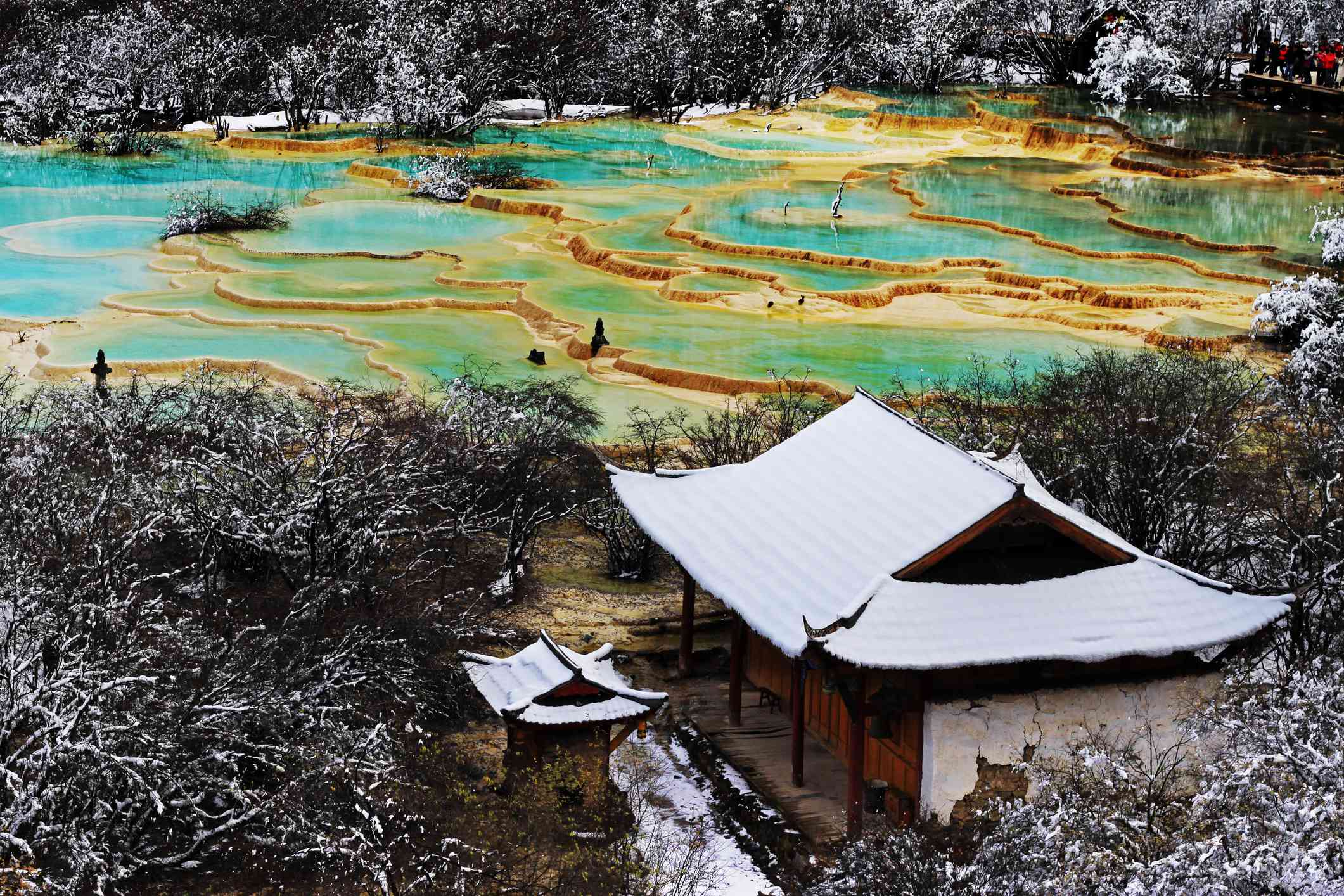 Templo cubierto de nieve y piscinas de travertino de Huanglong en invierno