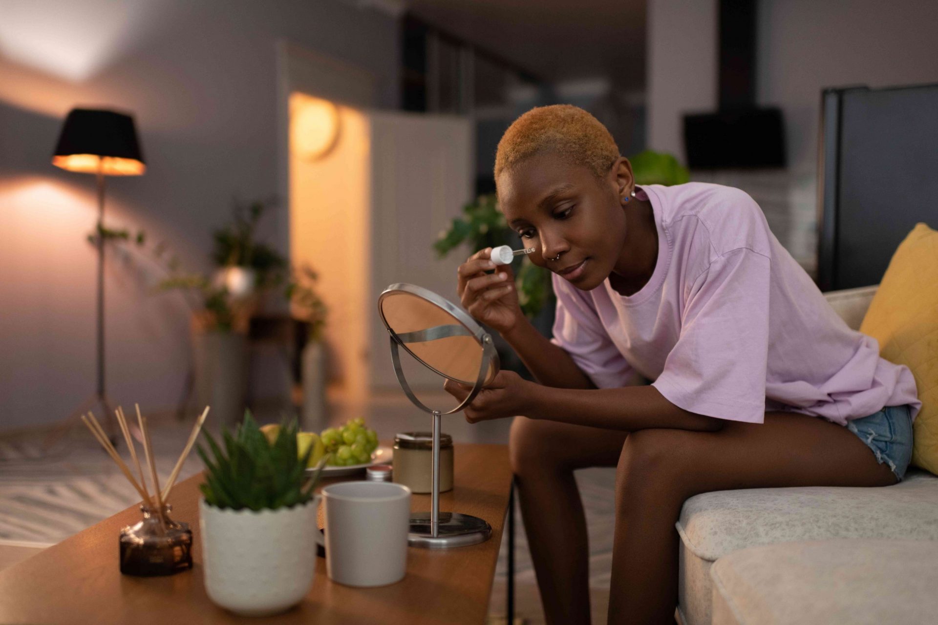 Mujer negra aplicando un producto cosmético en la cara en casa