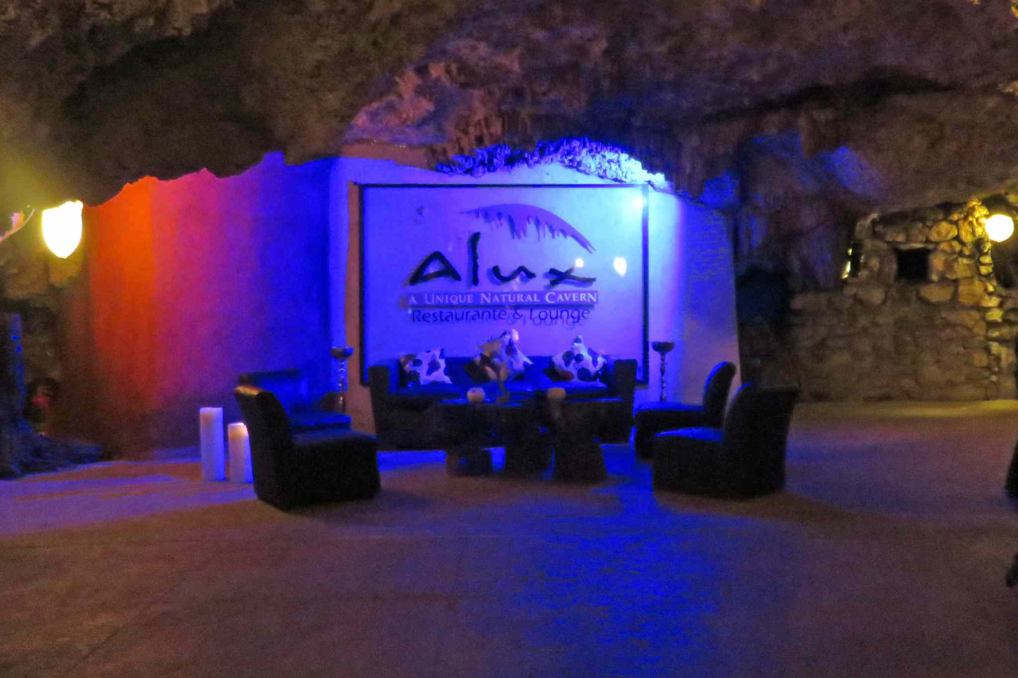 Cartel del restaurante y sofás con luz azul en una cueva