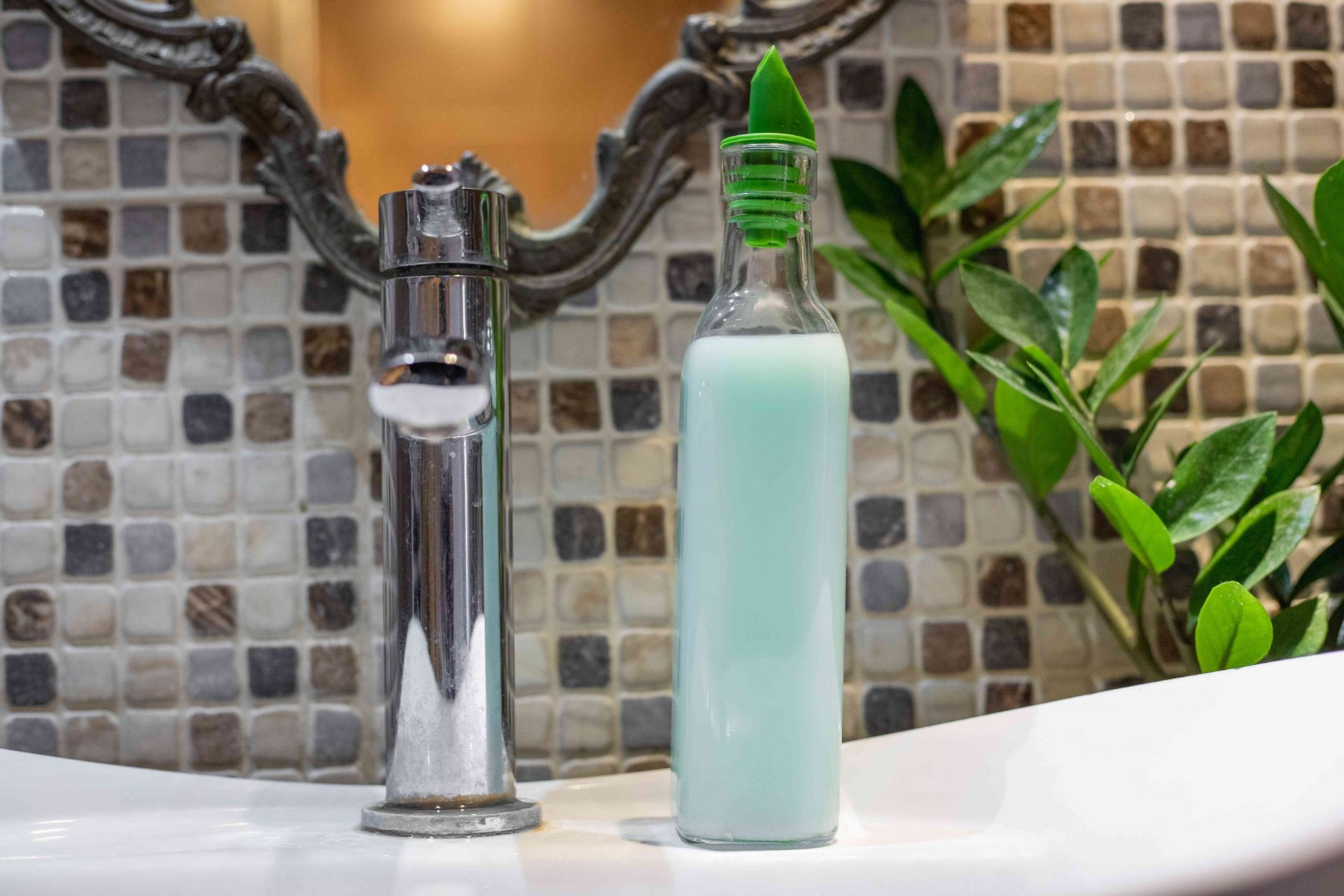 La botella de cristal del lavabo se convierte en un dispensador de jabón con tapa verde