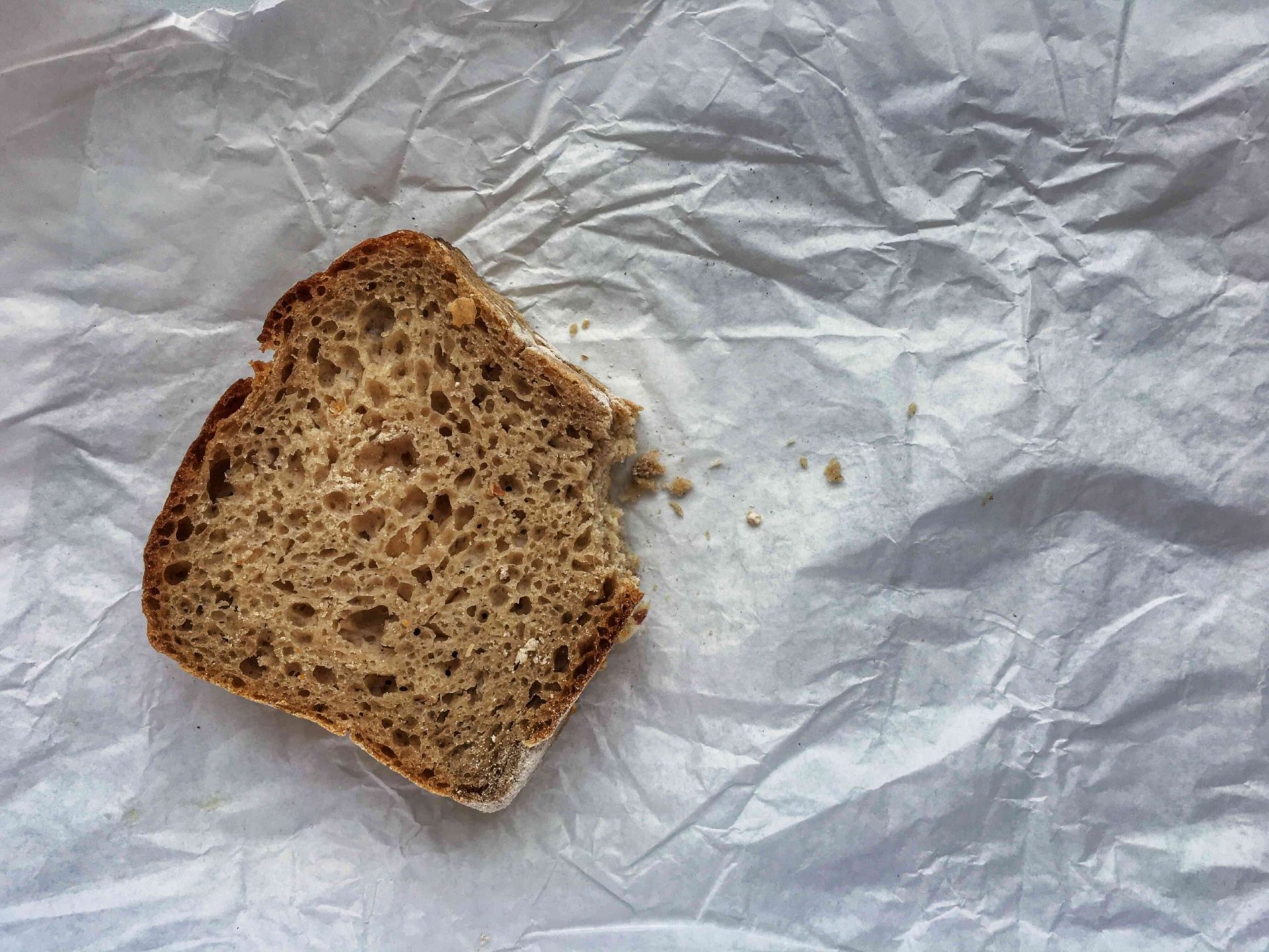 Vista en ángulo alto del pan comido sobre el papel arrugado