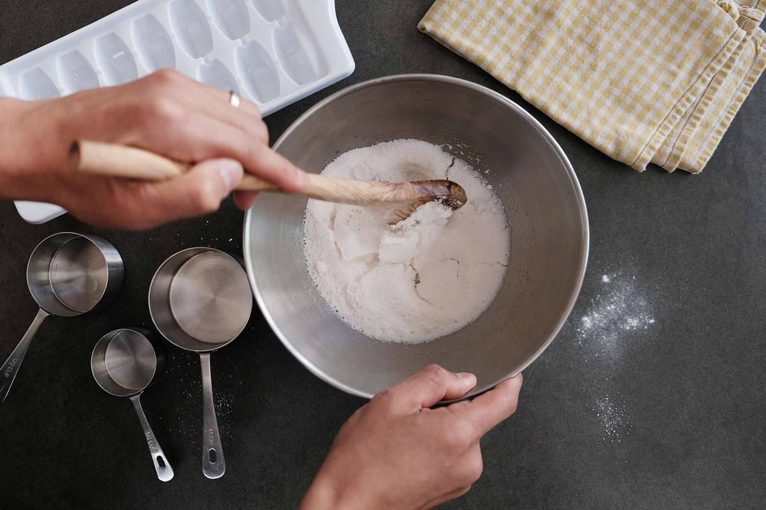 manos mezclan el jabón seco en un cuenco de acero inoxidable para hacer vainas de lavado