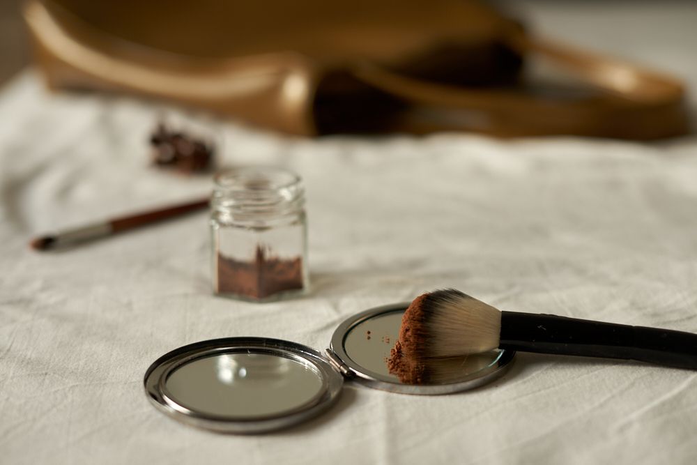 Bronceador DIY hecho con polvo de cacao en tarro de cristal con brocha de maquillaje