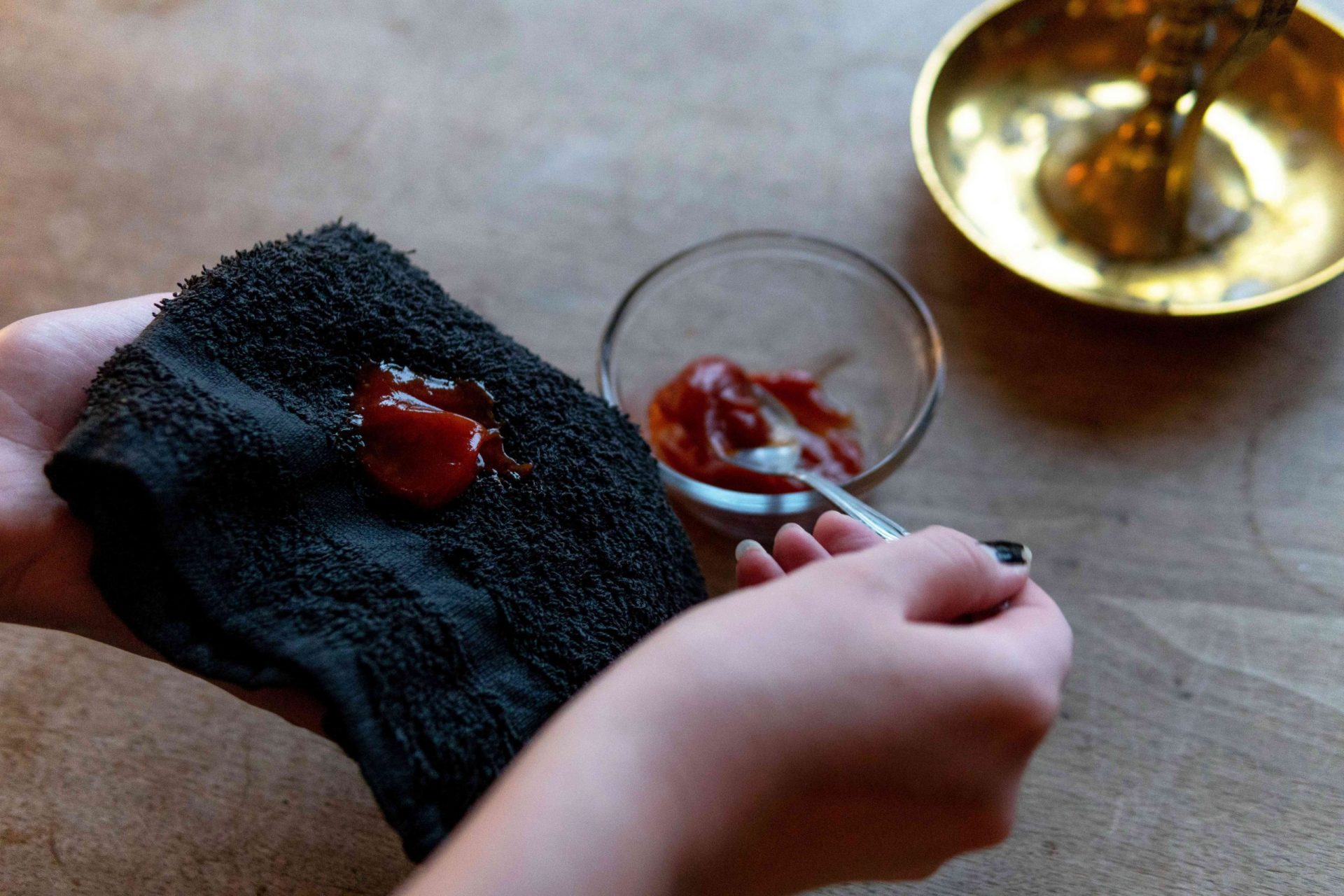 la mano utiliza una cuchara para recoger el ketchup en un paño