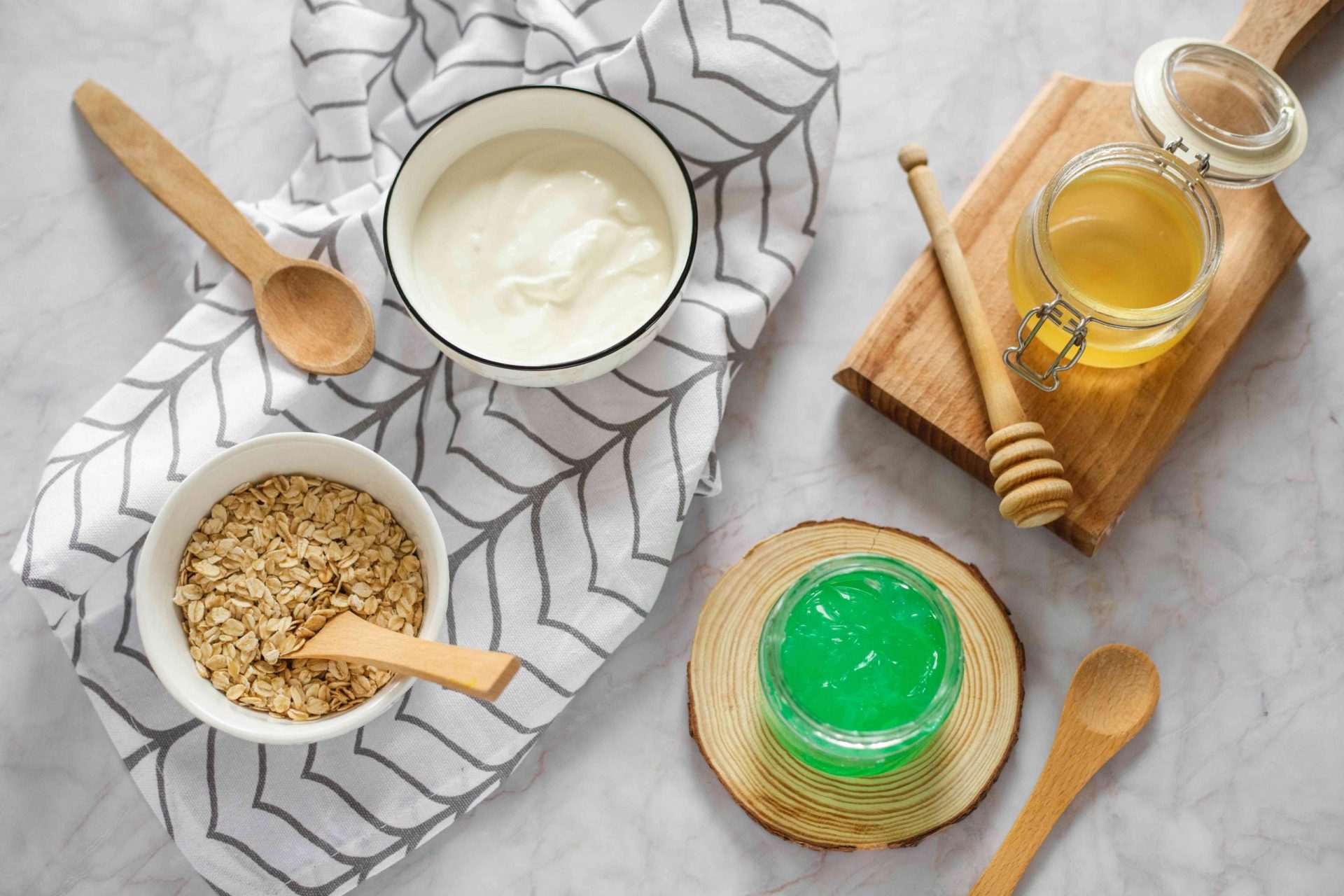 yogur, miel, aloe vera y avena seca en cuencos para variaciones de la mascarilla de pepino diy