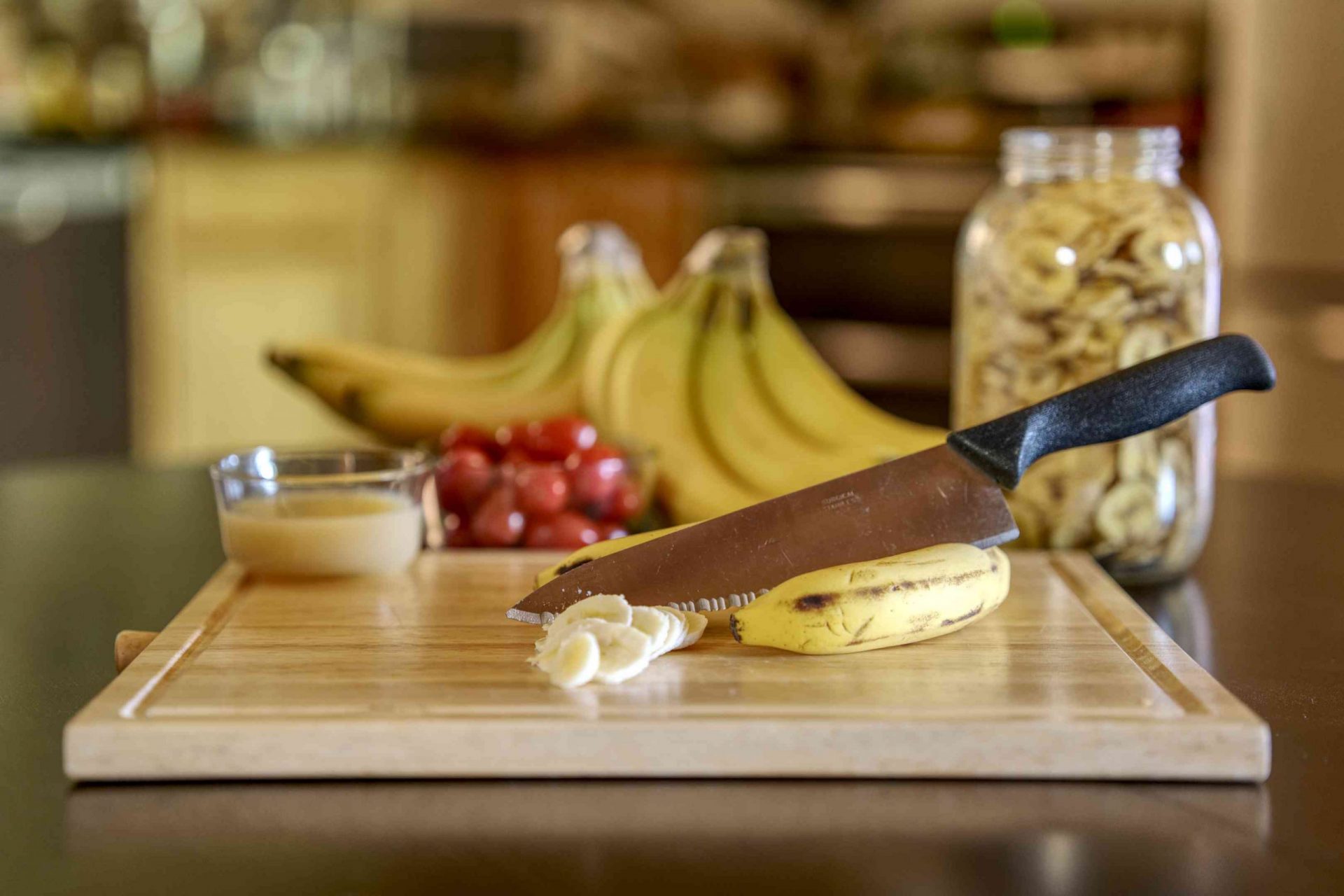 muestra de suministros de chips de plátano deshidratados, incluyendo un gran cuchillo de chef y una tabla de cortar