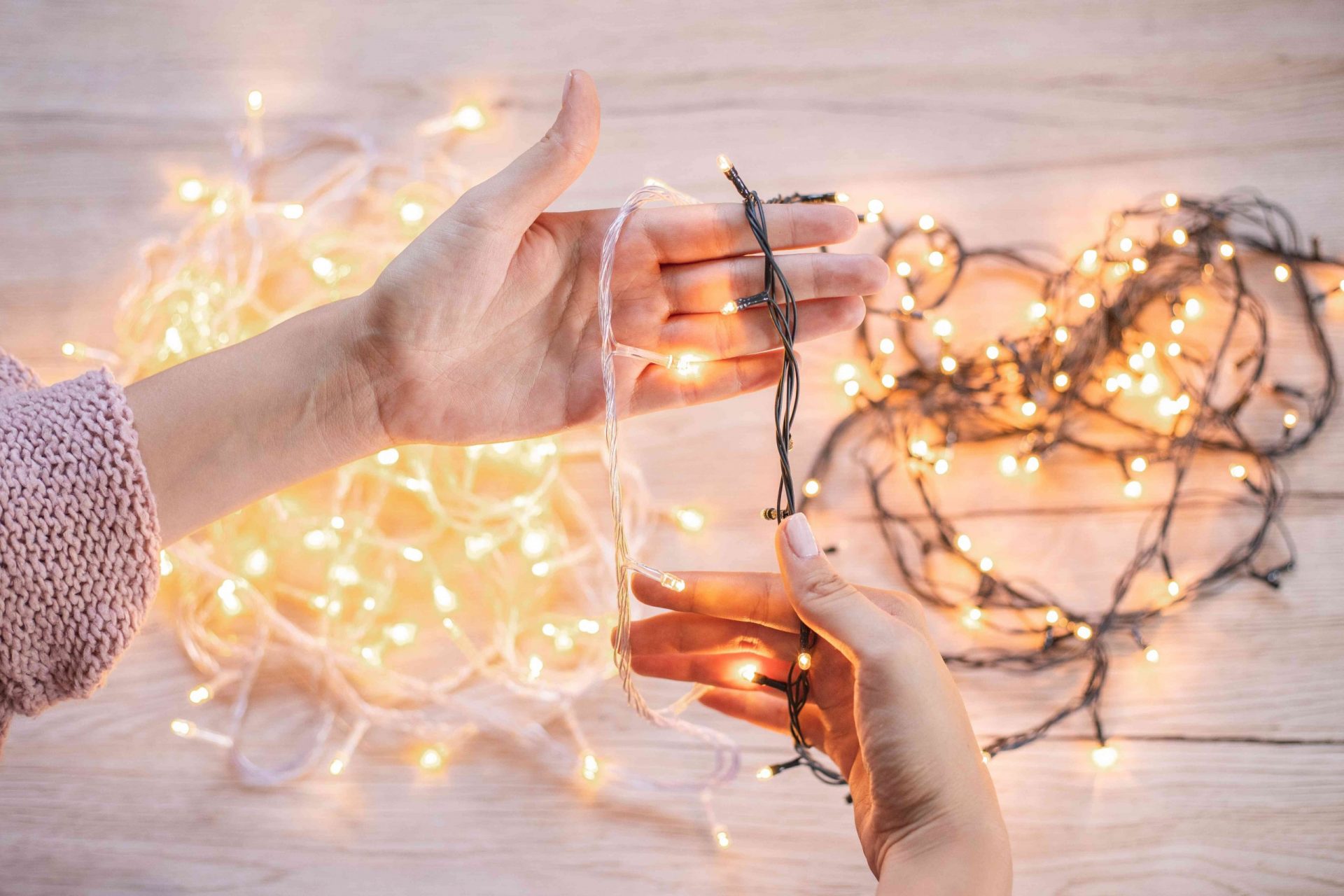 manos comparan diferentes paquetes de luces LED navideñas brillantes