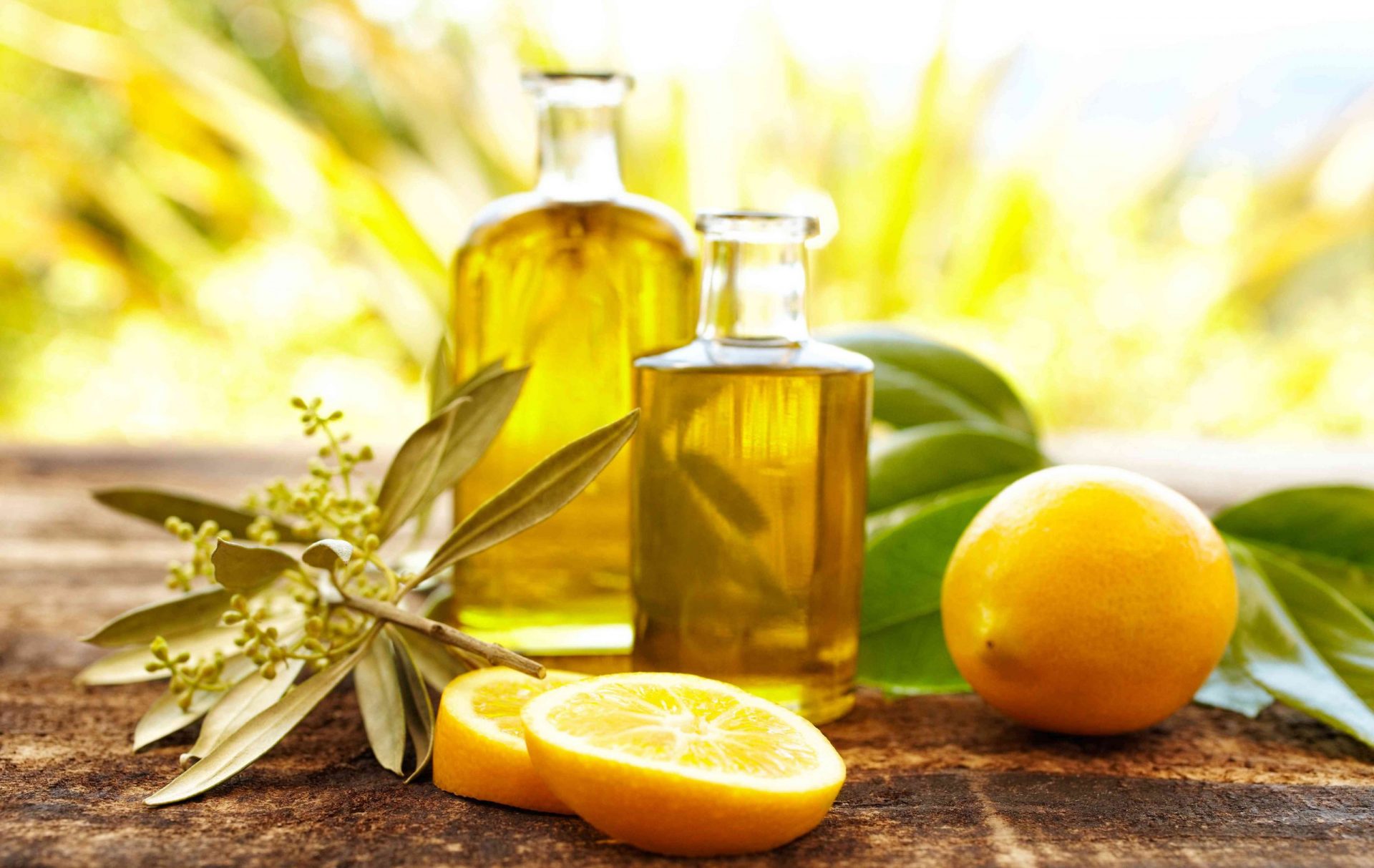 Masaje de botellas de aceite con limones y rama de olivo
